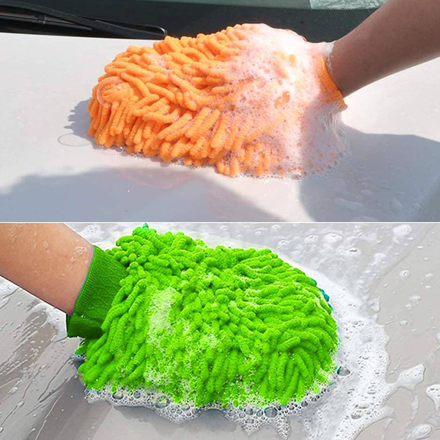 Hand trägt Chenille-Autowaschmittel in Orange und Grün und schrubbt eine nasse Oberfläche, wodurch Seifenschaum entsteht.