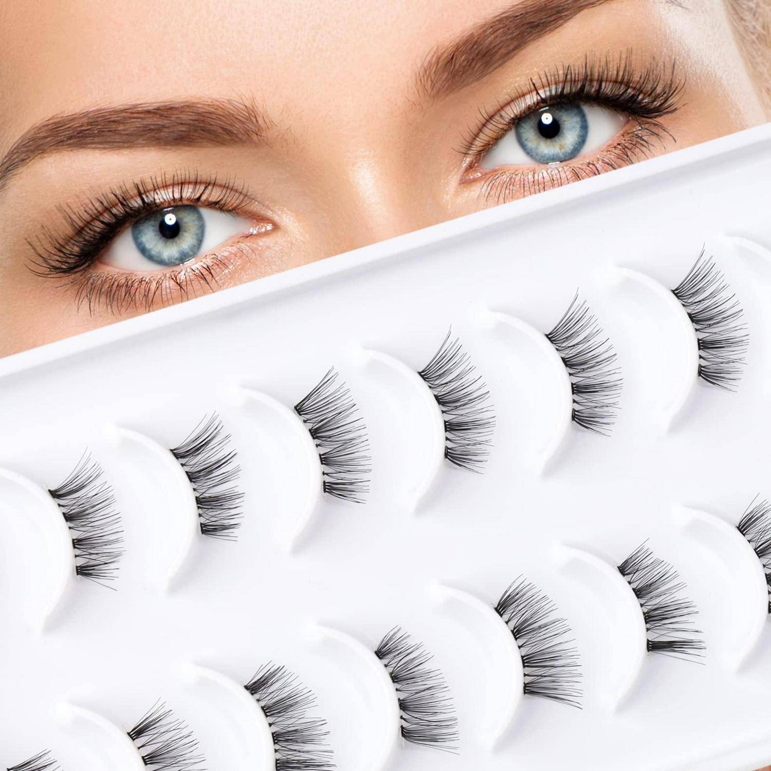 Nahaufnahme von blauen Augen über einer Auswahl von künstlichen Wimpern auf einem weißen Tablett, was auf Wimpernverlängerungen oder Schönheitsprodukte hindeutet.