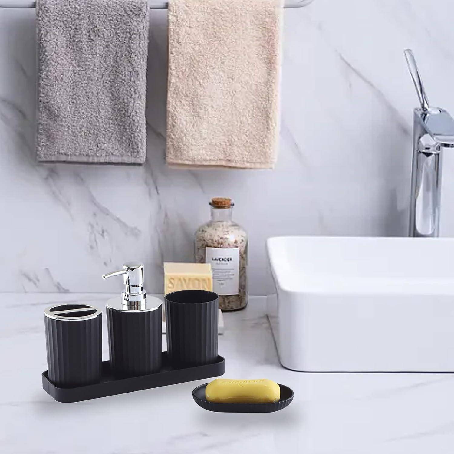 Moderner Badezimmerwaschbereich mit zwei hängenden Handtüchern, weißem Becken und Chromarmatur, sowie schwarzen Seifenspendern, Seifenschale und einer dekorativen Flasche auf einer Marmor-Arbeitsplatte.