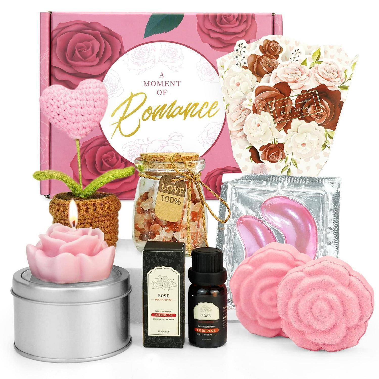 Ein romantisches Geschenkset mit rosa Rosen-Themen-Verpackung, eine Herz-Formschnitt-Pflanze, eine Kerze, rosige Seife, Badeartikel und abgefüllte Rosenprodukte, die auf einer Displayfläche arrangiert sind.