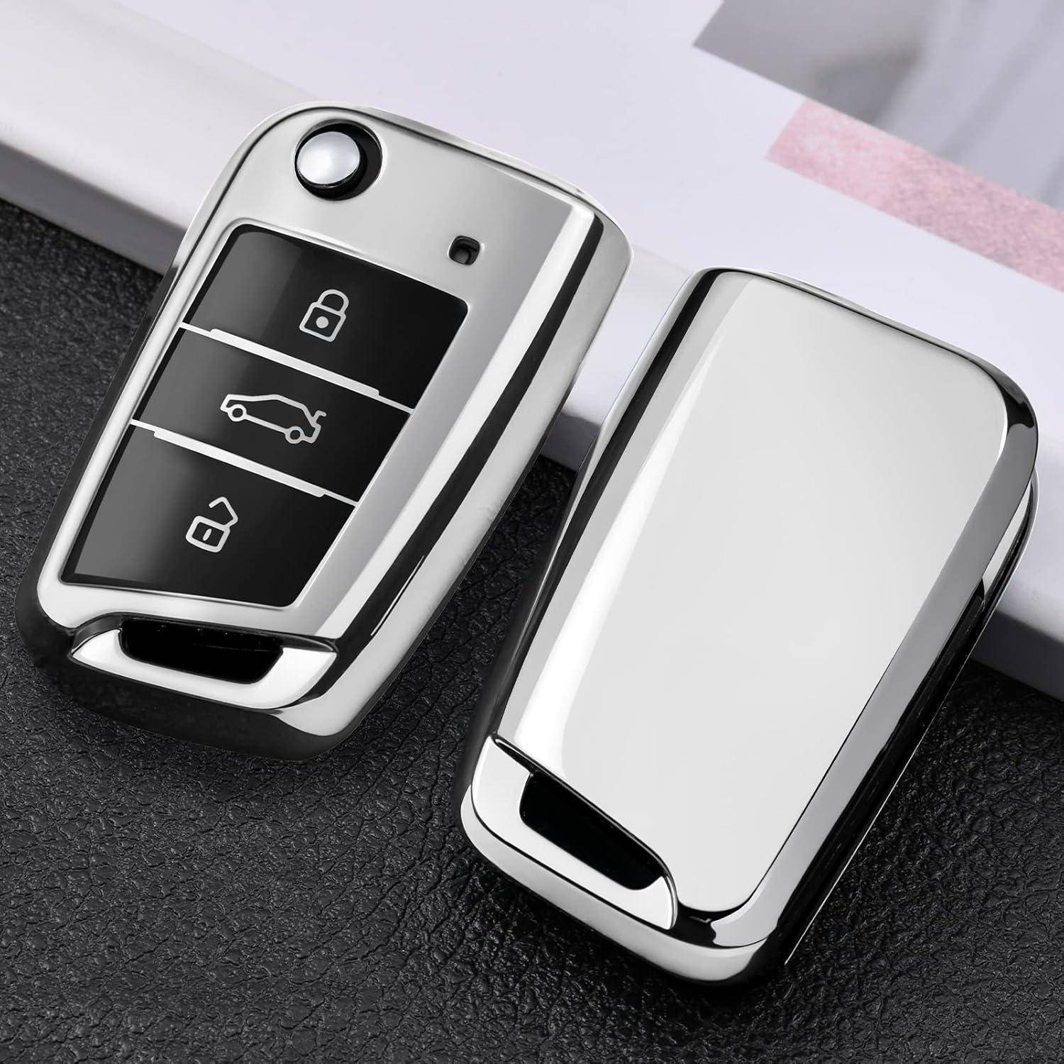 Zwei Chrome-Autoschlüssel-Fernbedienungen auf einer dunklen strukturierten Oberfläche, eine zeigt Sperr-, Auto- und Entsperr-Symbole.