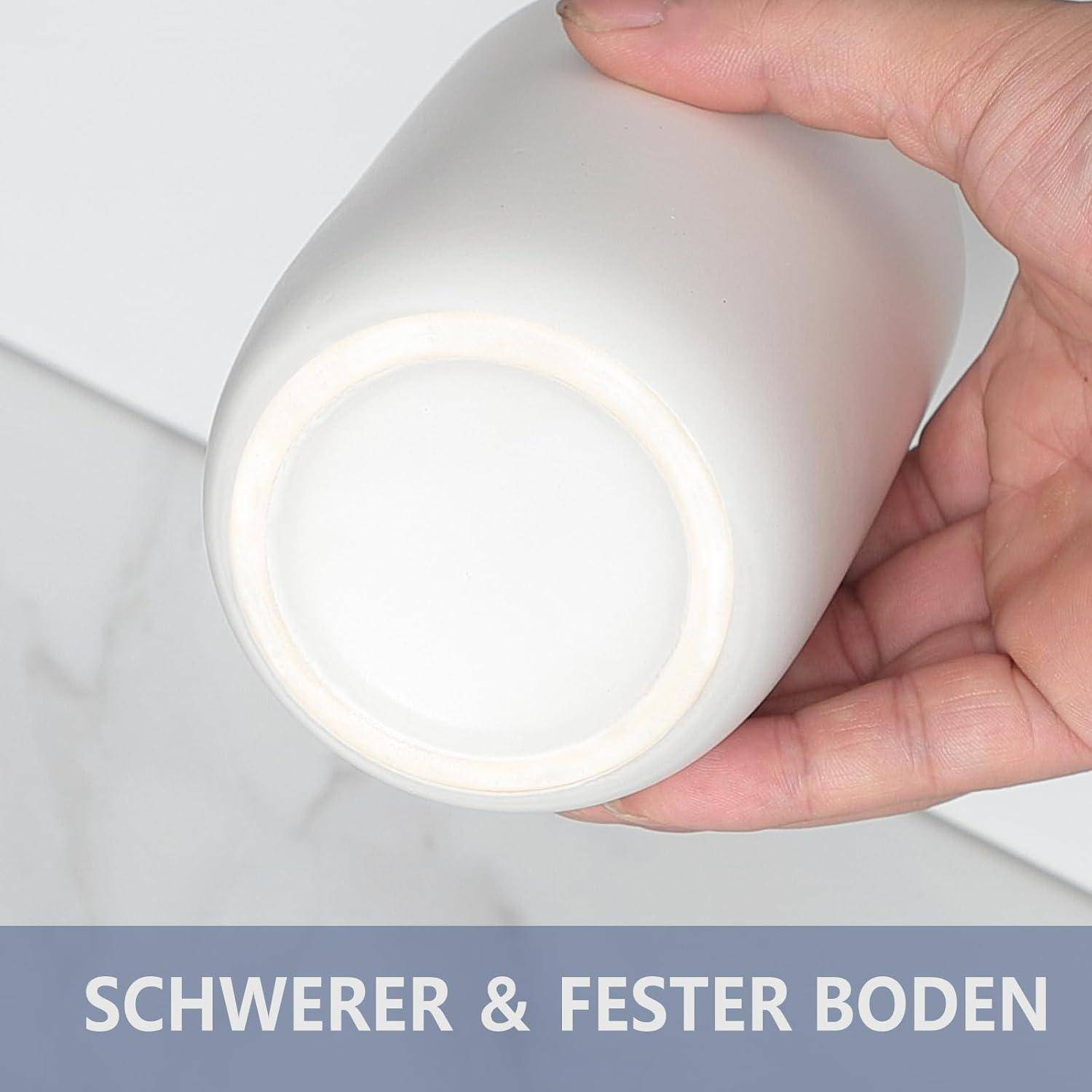 Nahaufnahme einer Hand, die eine weiße zylindrische Flasche mit einer dicken, stabilen Bodenfläche hält; der Text lautet „SCHWERER & FESTER BODEN