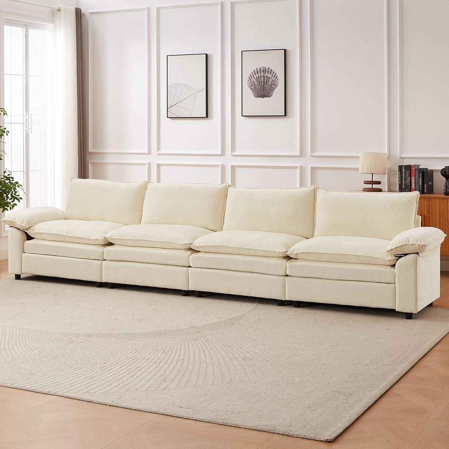 Cremefarbenes Ecksofa in einem hellen, minimalistischen Wohnzimmer mit gerahmten Wandkunstwerken, einer Stehlampe, Büchern und einem großen neutralen Teppich.