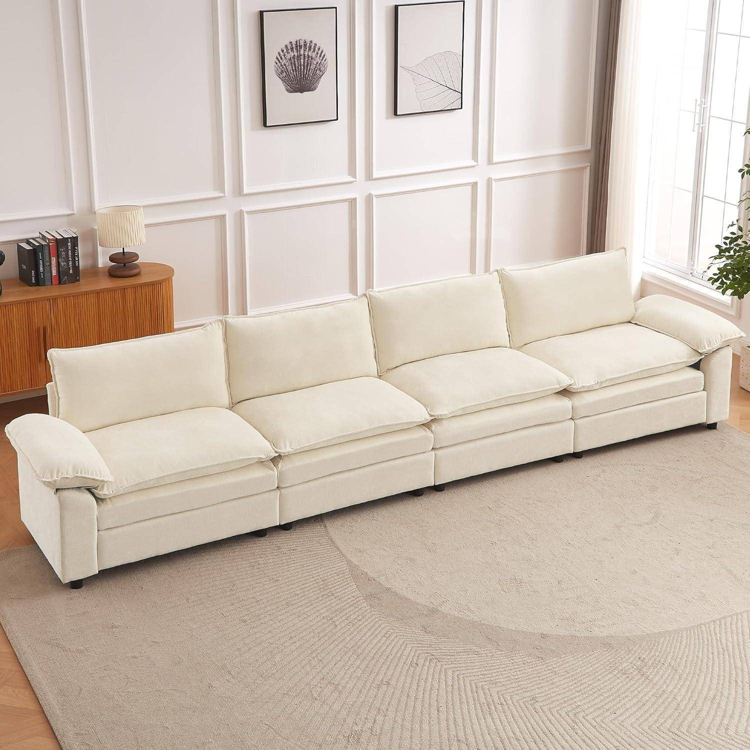 Cremefarbenes Sektionalsofa in einem hellen Wohnzimmer, dargestellt vor einer getäfelten Wand mit rahmengerahmter Kunst und einem großen hellellen Teppich.