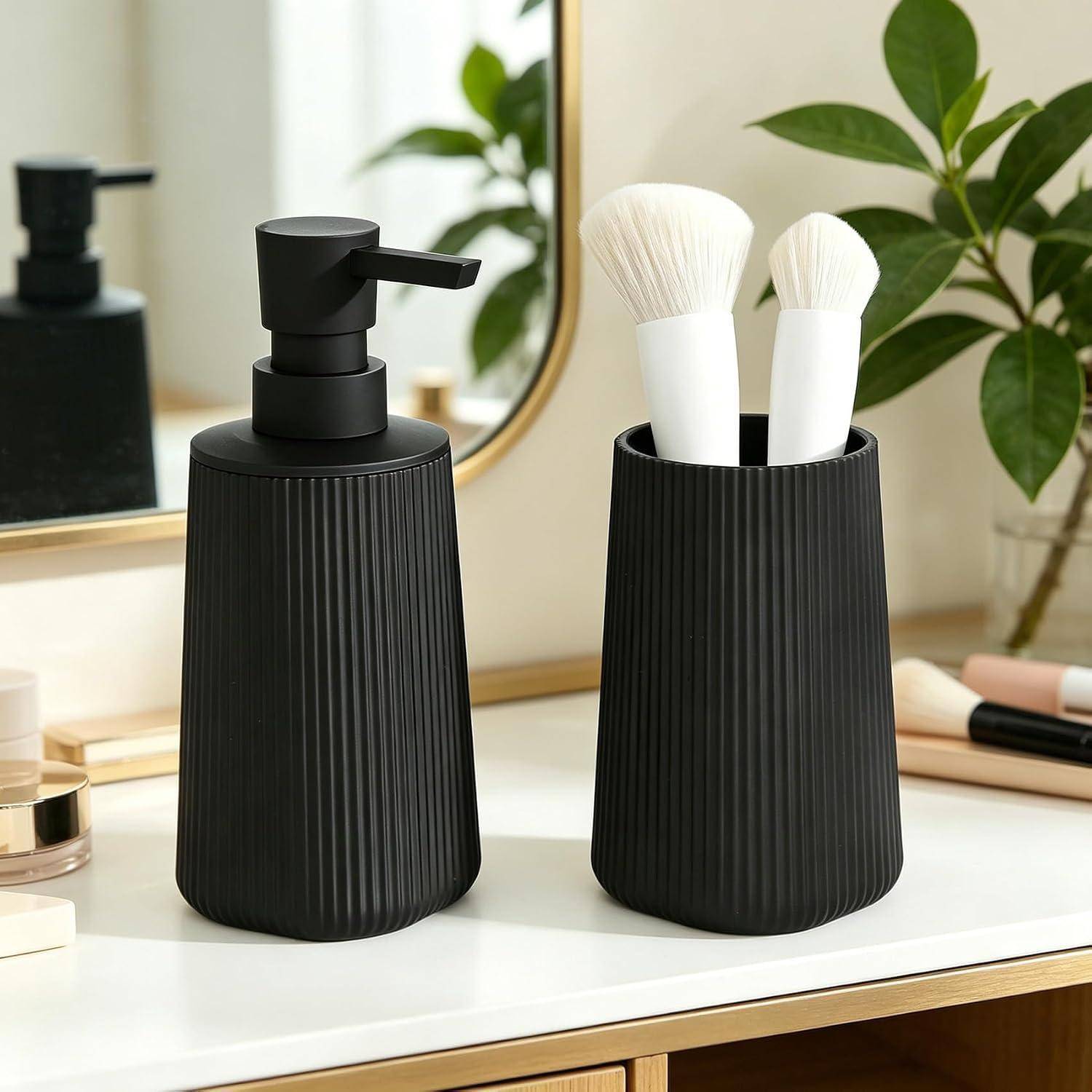Schwarze gerippte Badezimmerspender auf einem Waschtisch, einer mit Pumpaufsatz und einer mit zwei Makeup-Pinseln, mit Spiegel und Pflanzen im Hintergrund.