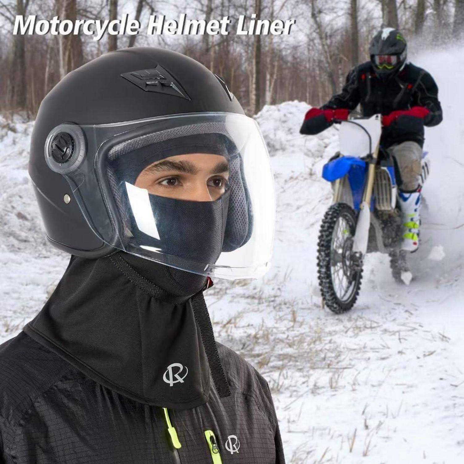Nahaufnahme einer Person, die einen schwarzen Motorrad-Helmfutter und ein klares Visier trägt, mit einem Dirt-Bike-Fahrer im verschneiten Hintergrund.