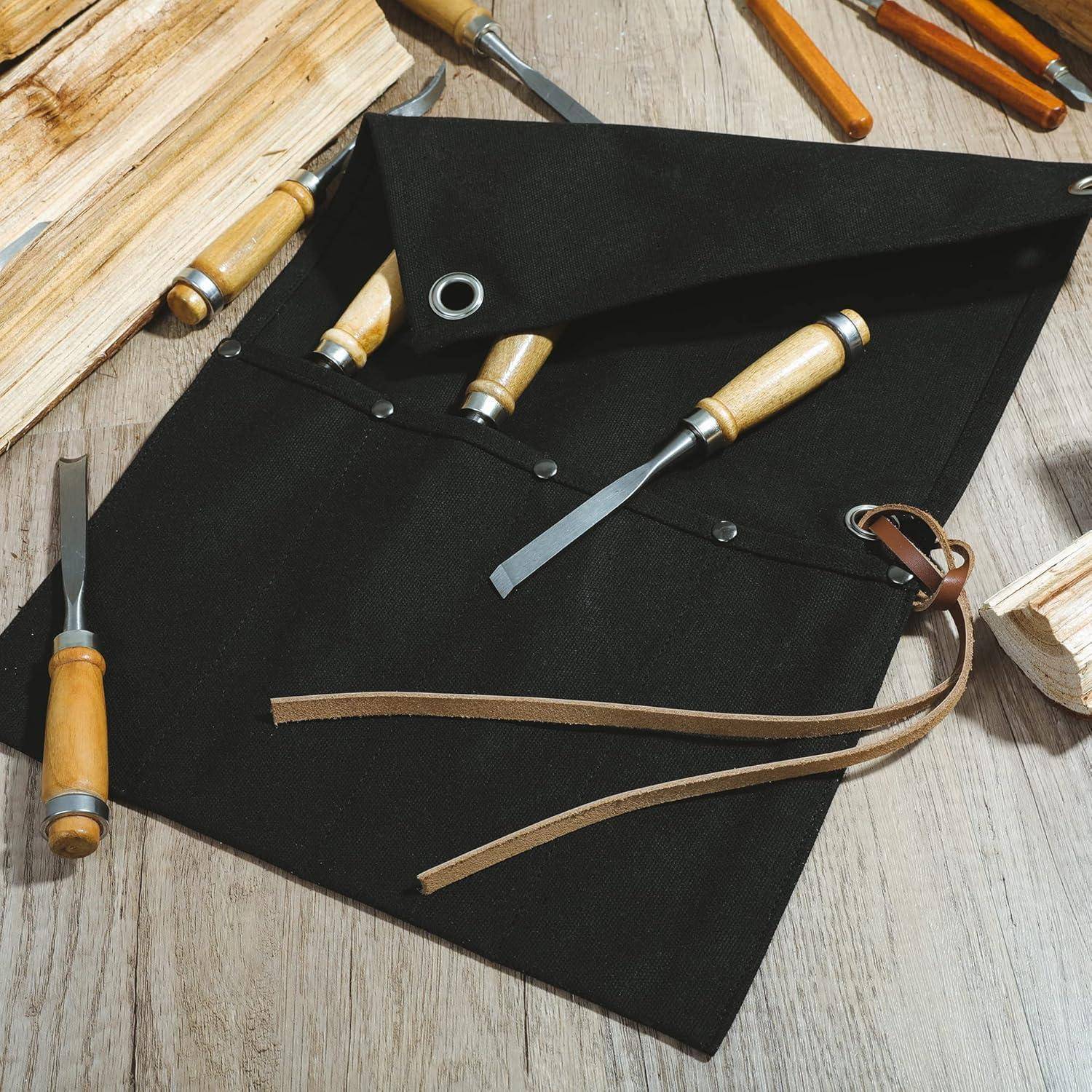 Holzschnitzwerkzeug-Rolltasche mit Meißeln und Hohlmeißeln auf einer Holzarbeitsfläche.