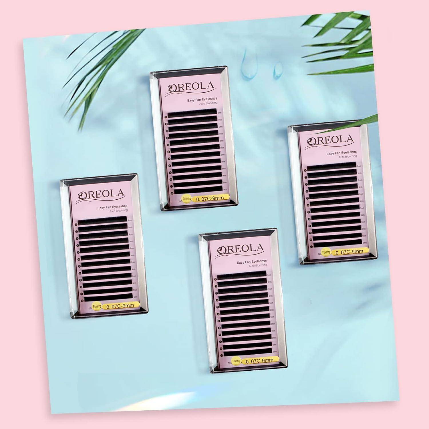 Vier REOLA-Wimpernverlängerungs-Tabletts mit schwarzen Wimpernstreifen, angeordnet auf einem pastellblauen Hintergrund mit Palmblättern.