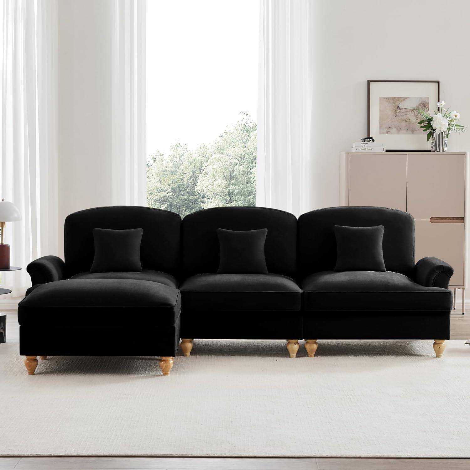 Schwarzes Dreisitzer-Sofa mit passenden Kissen in einem hellen, minimalistischen Wohnzimmer