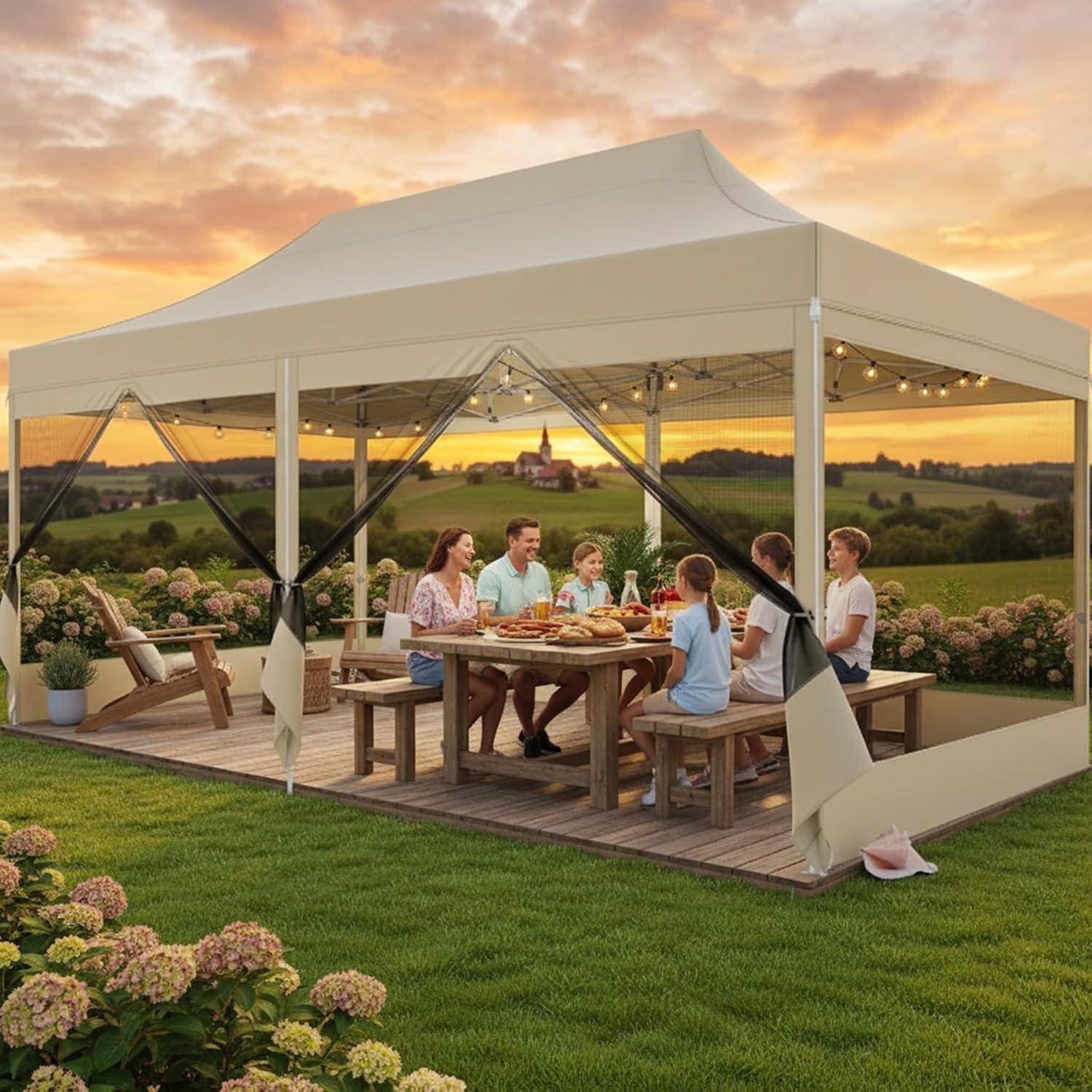 Familie sitzt bei einem Picknick an einem Picknicktisch unter einem beigen Baldachindach auf einer Grasfläche bei Sonnenuntergang, mit einer ländlichen Landschaft im Hintergrund.