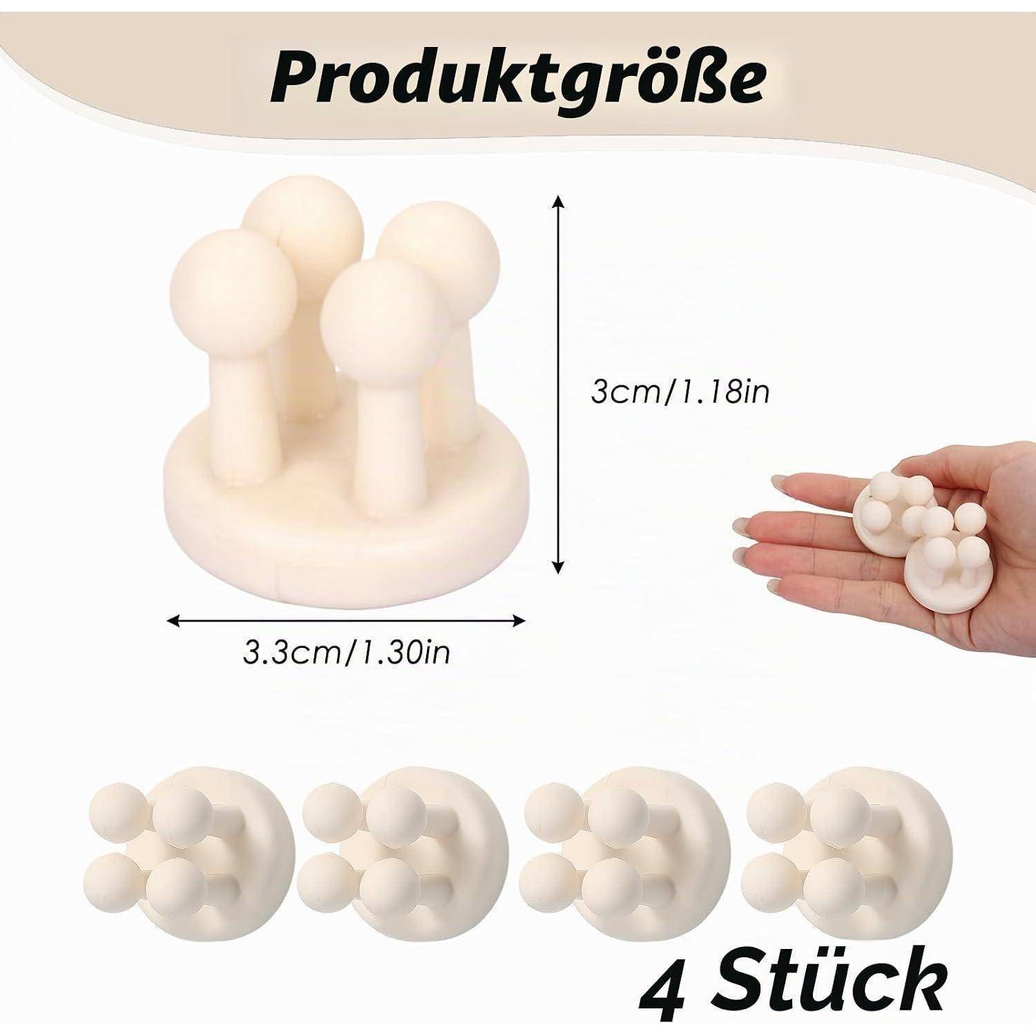 Produktgrößengrafik eines kleinen cremefarbenen Massagegeräts: 3 cm hoch, 3,3 cm breit, in einer Hand gezeigt; Set enthält 4 Stück.