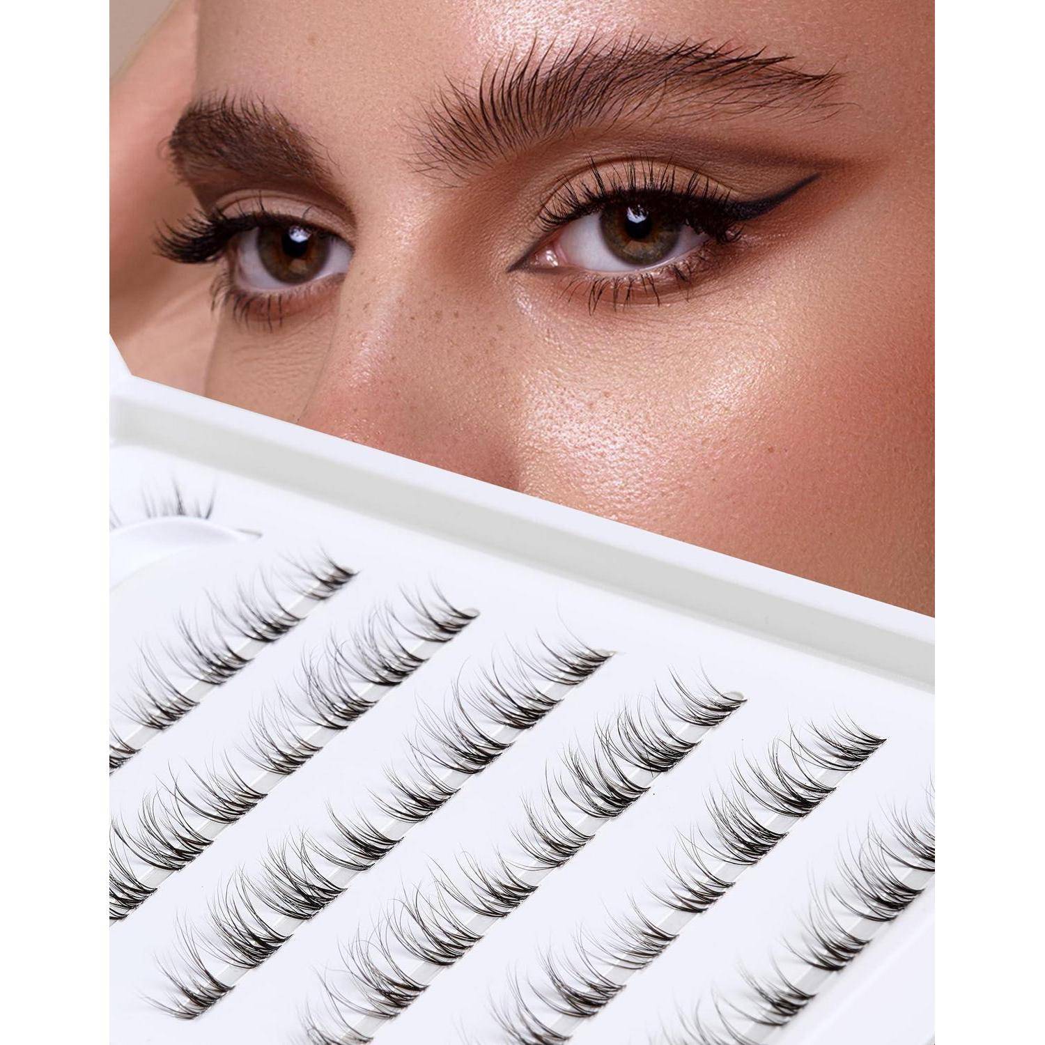 Nahaufnahme der Augen einer Frau mit dramatischem Eyeliner, die ein Tablett mit künstlichen Wimpern in Reihen angeordnet hält.