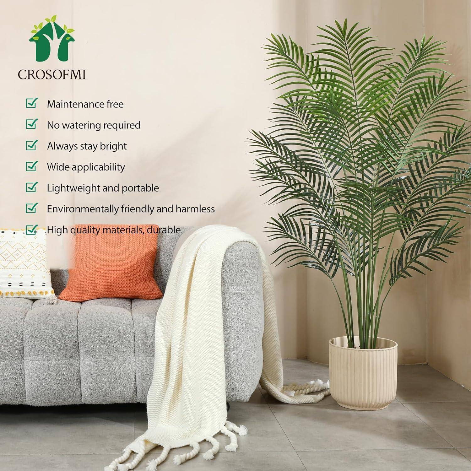 Künstliche Topfpalme im Wohnzimmer neben einem Sofa; Text hebt wartungsfrei, kein Gießen erforderlich, immer hell, leicht und langlebig hervor.