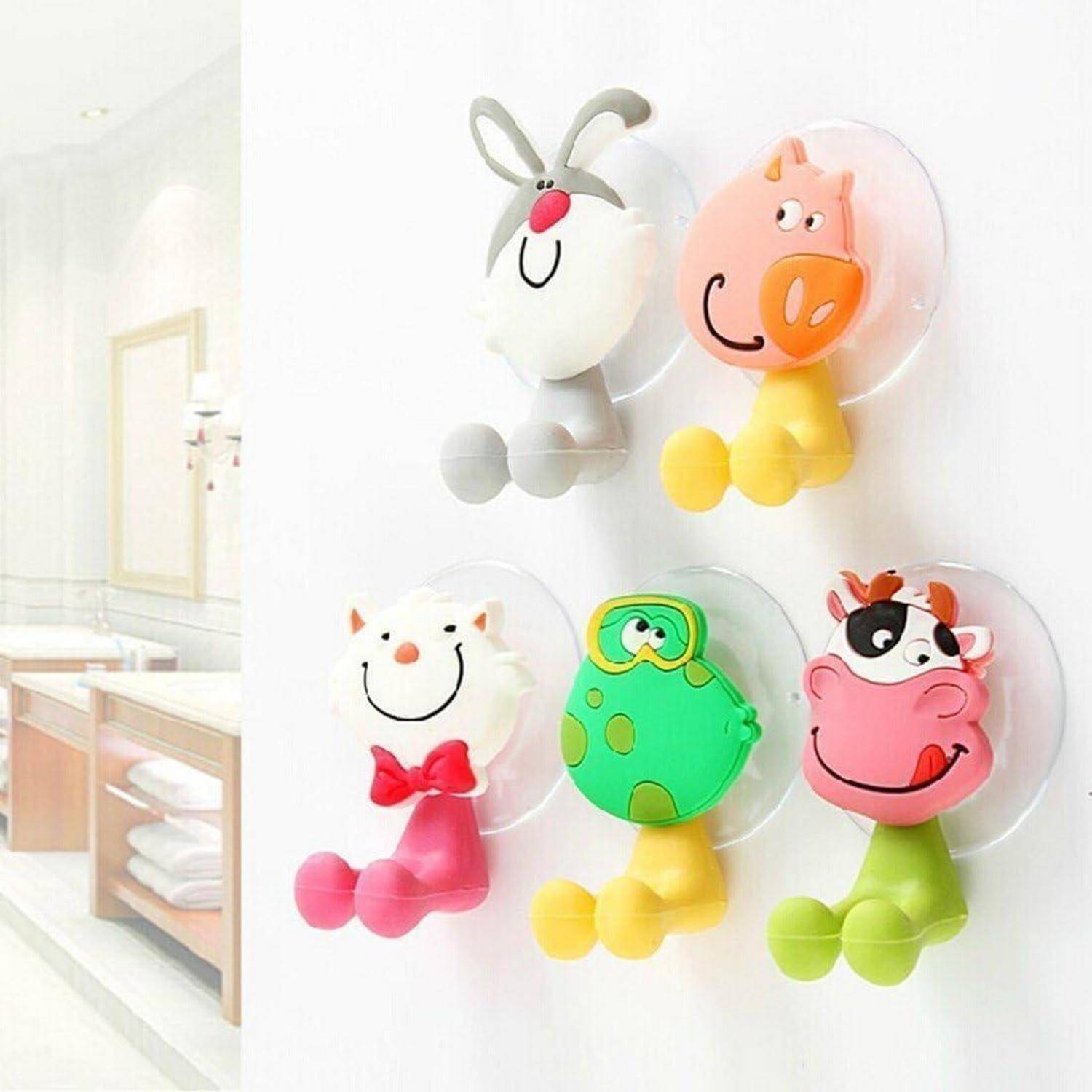 Fünf farbenfrohe tierförmige Wandhaken mit Saugnäpfen, die in einem Gitter auf einer weißen Wand angeordnet sind.