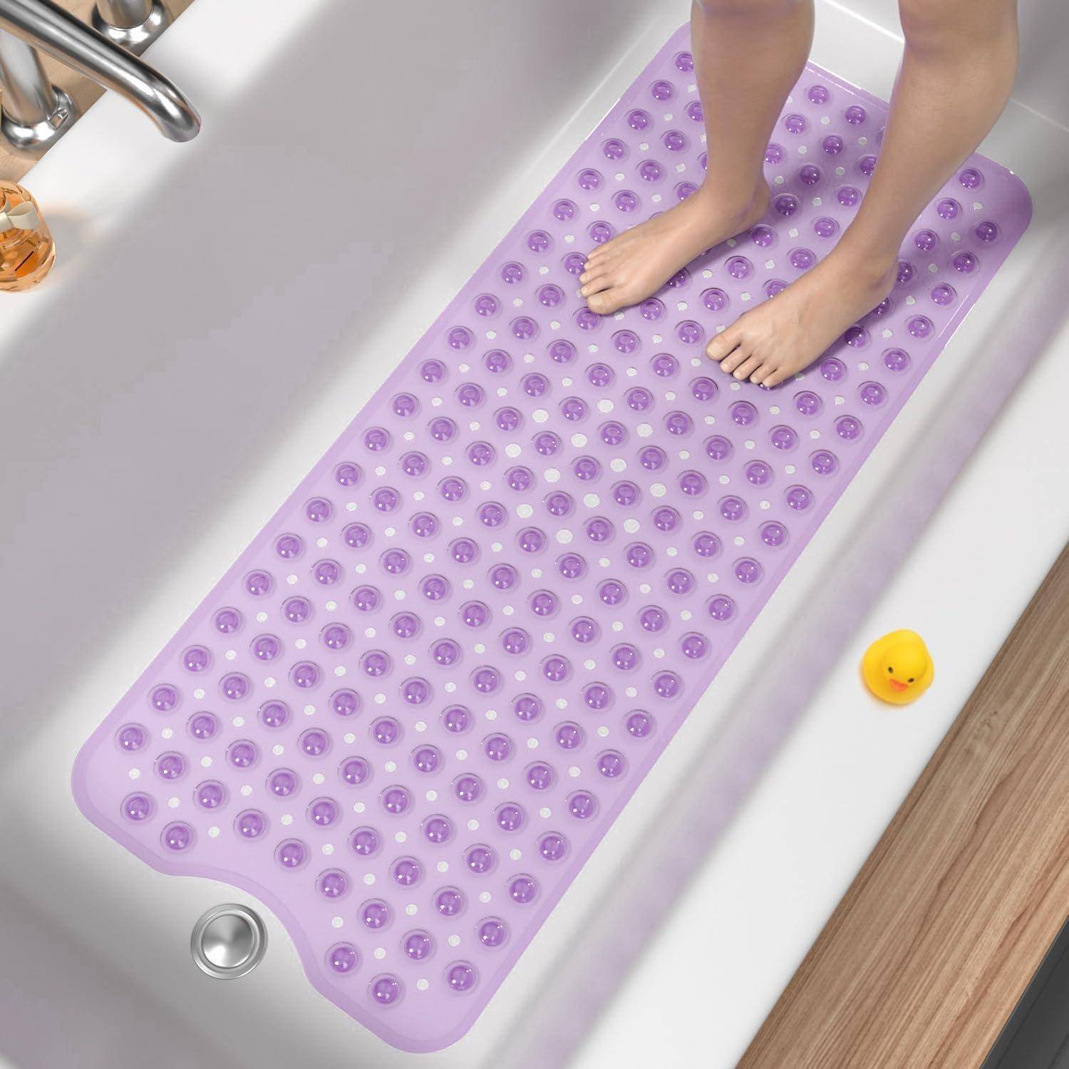 Füße, die auf einer violetten rutschfesten Badematte in einer Badewanne stehen, mit einem gelben Badespielzeug in der Nähe.