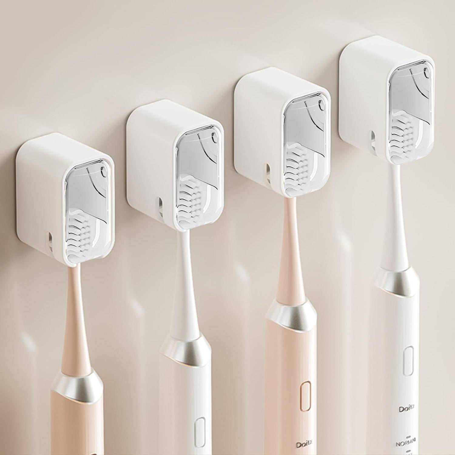 Vier elektrische Zahnbürsten in Pastellfarben sind aufrecht an einer hellen Wand angebracht und zeigen ihre schlanke Griffform und das Bürstenkopf-Design.