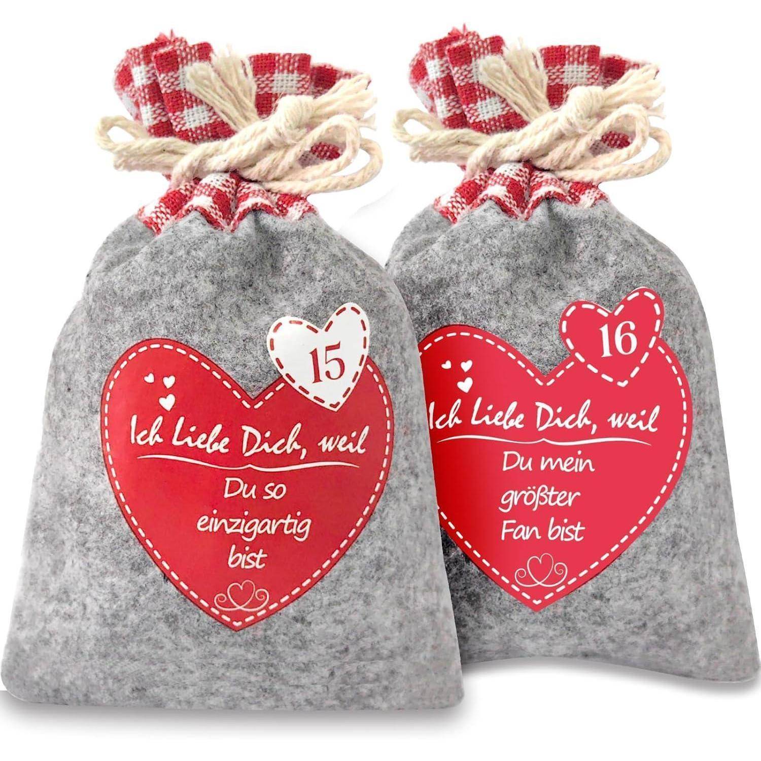 Zwei graue Filzgeschenktaschen mit roten Herzetiketten und Schnurbindern, nummeriert 15 und 16, mit deutschen Valentinstagsbotschaften.