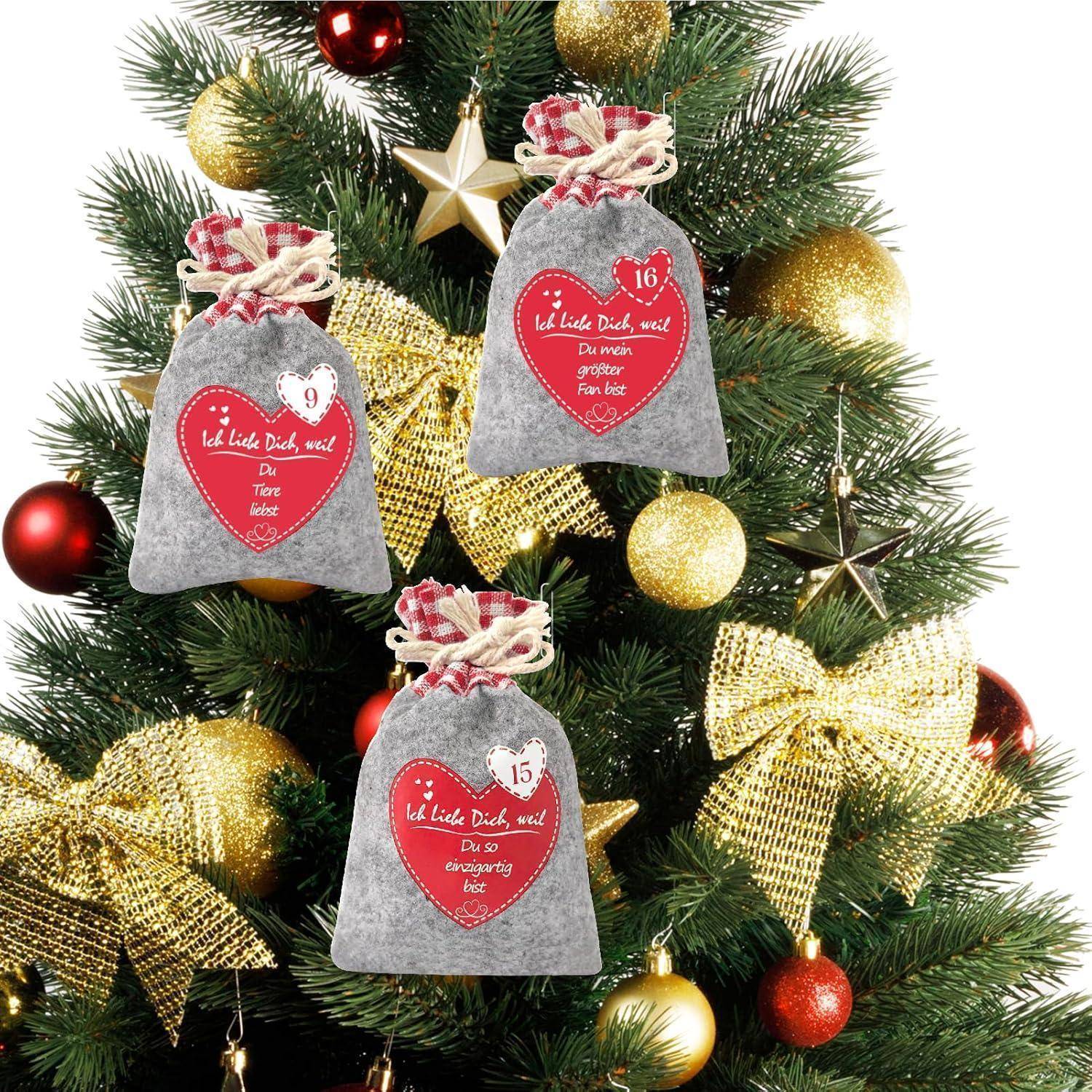 Ein geschmückter Weihnachtsbaum mit goldfarbenen Schleifen und Verzierungen, mit drei grauen Geschenktaschen mit Kordelzug, die mit roten Herzen und den Nummern 9, 15 und 16 gekennzeichnet sind.