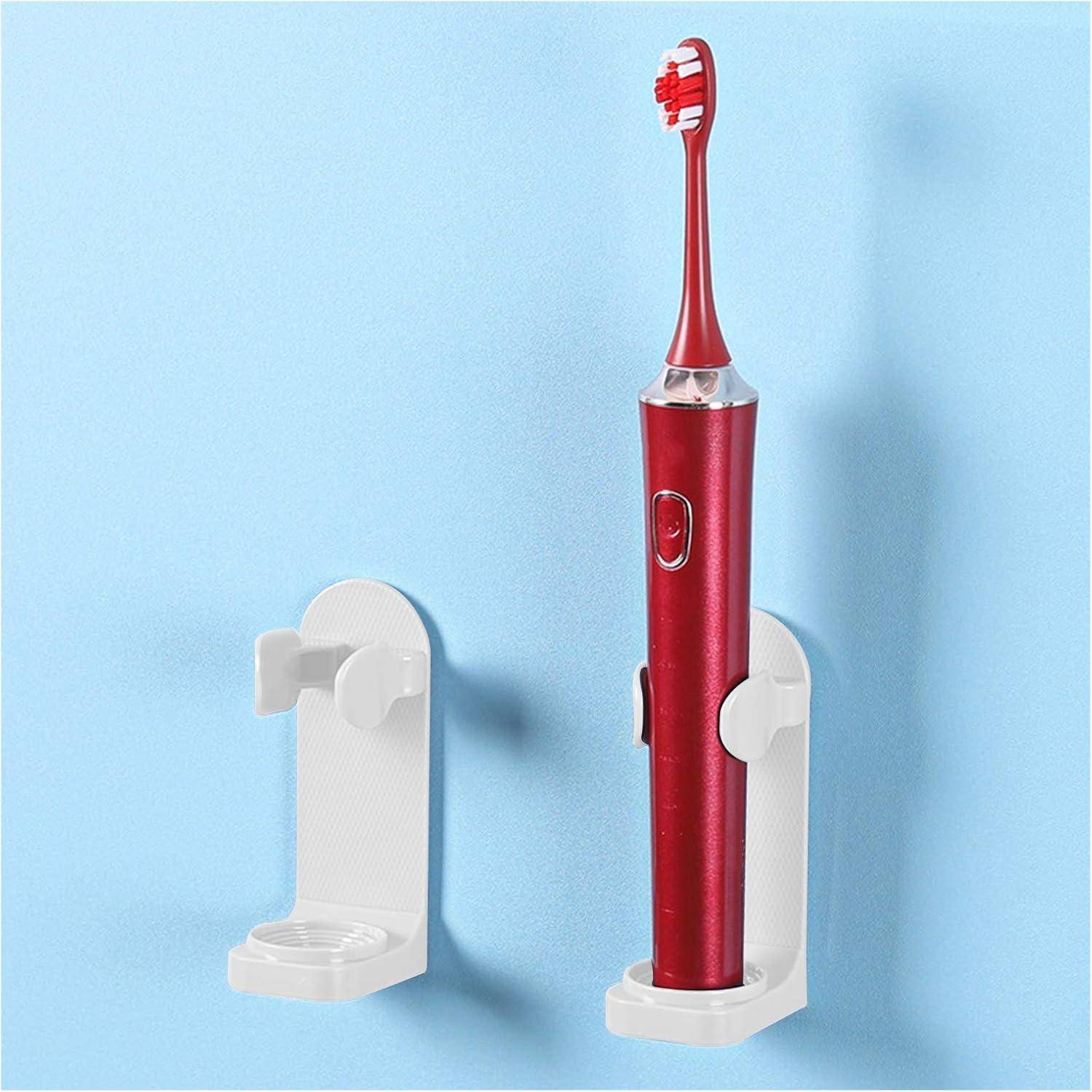 Rote elektrische Zahnbürste, die in einem weißen wandmontierten Halter auf blauem Hintergrund steht, mit einem leeren passenden Halter daneben.