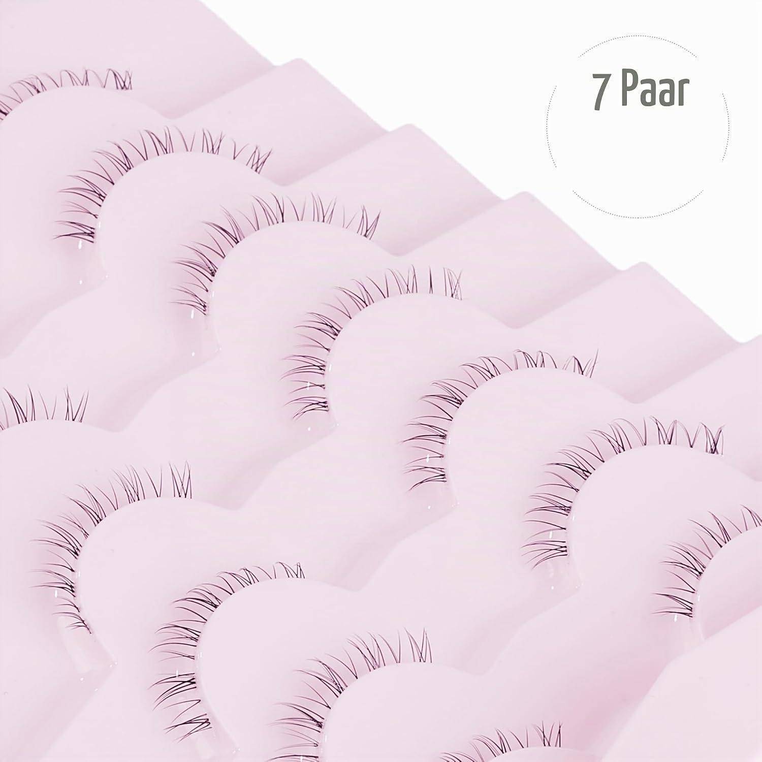 Packung mit 7 rosa künstlichen Wimpern in überlappenden Reihen auf weißem Hintergrund angeordnet.