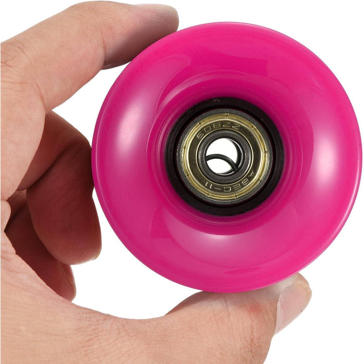 Nahaufnahme einer Hand, die ein leuchtend rosa Rad mit einem sichtbaren Kugellager hält, wahrscheinlich ein Skateboard- oder Rollschuhrad.
