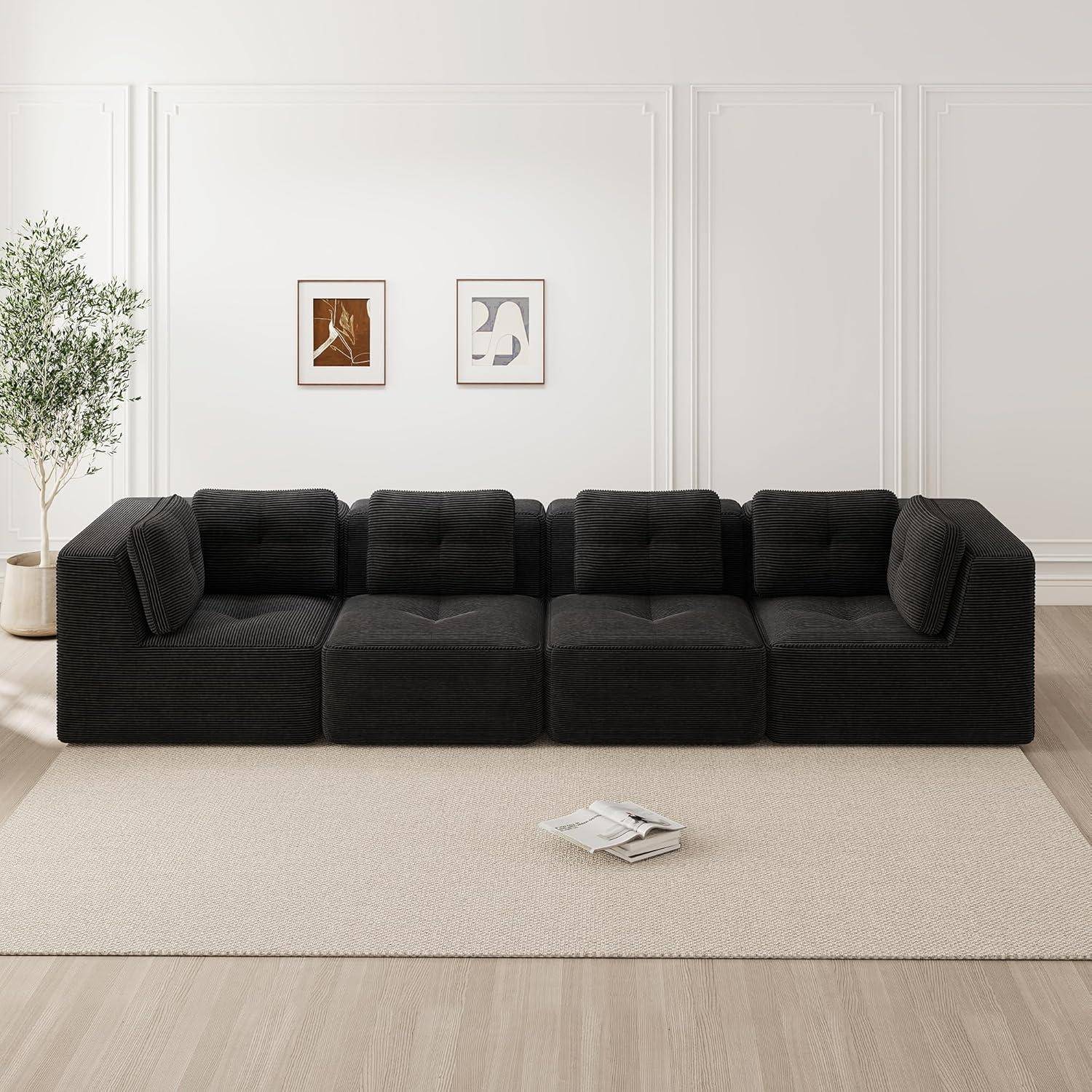 Ein schwarzes modulares Sofa sitzt in einem minimalistischen Wohnzimmer mit gerahmter Wandkunst, einer Topfpflanze und einem hellen Teppich.