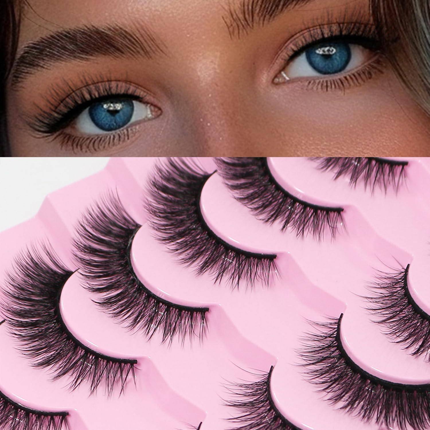 Nahaufnahme blauer Augen über einer Auswahl von künstlichen Wimpernstreifen auf rosa Untergrund, die kosmetische Wimpernprodukte zur Schönheitsverstärkung zeigt.