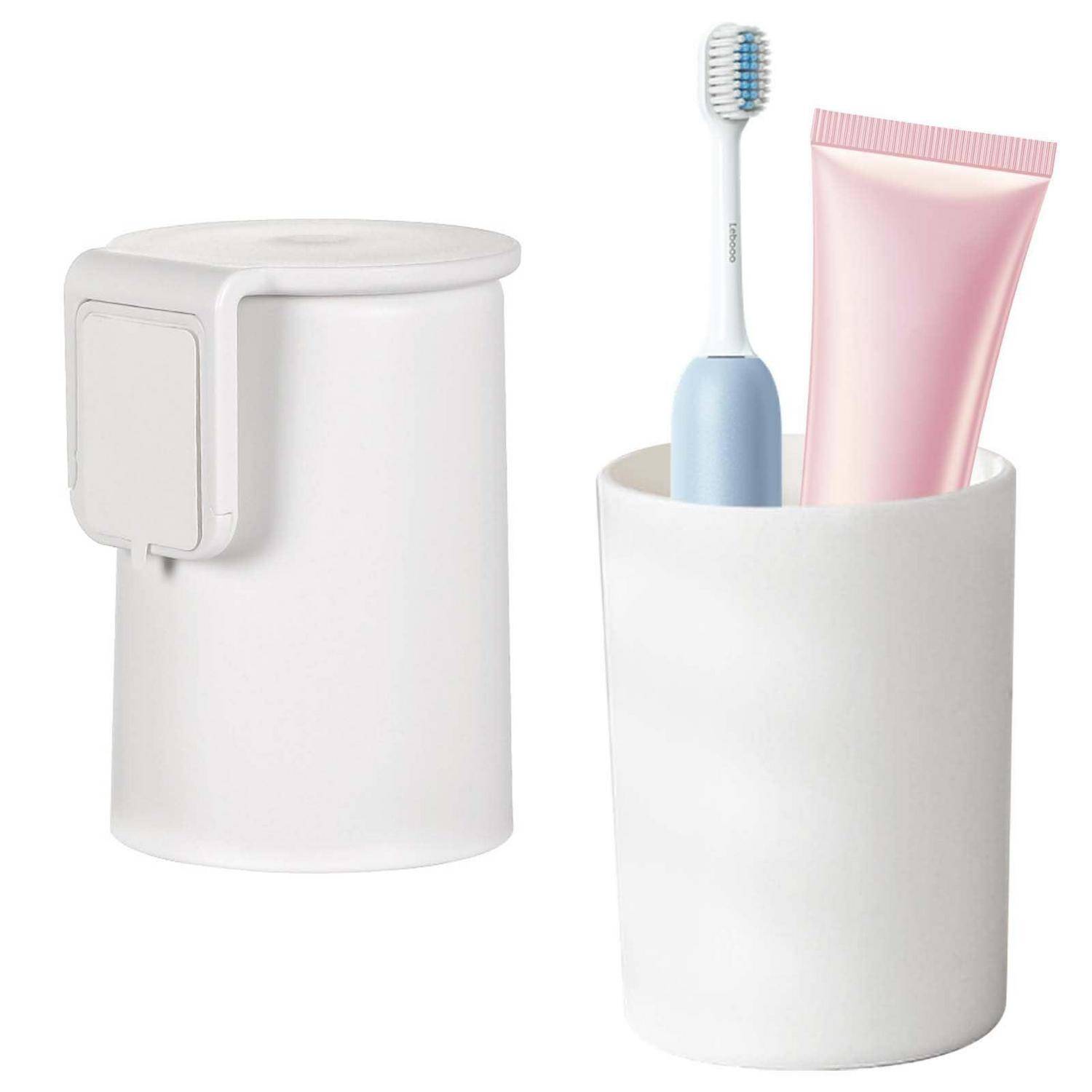 Weißer, wandmontierter Badezimmerbecher-Halter neben einem Becher, der eine Zahnbürste und eine rosa Zahnpastatube hält.