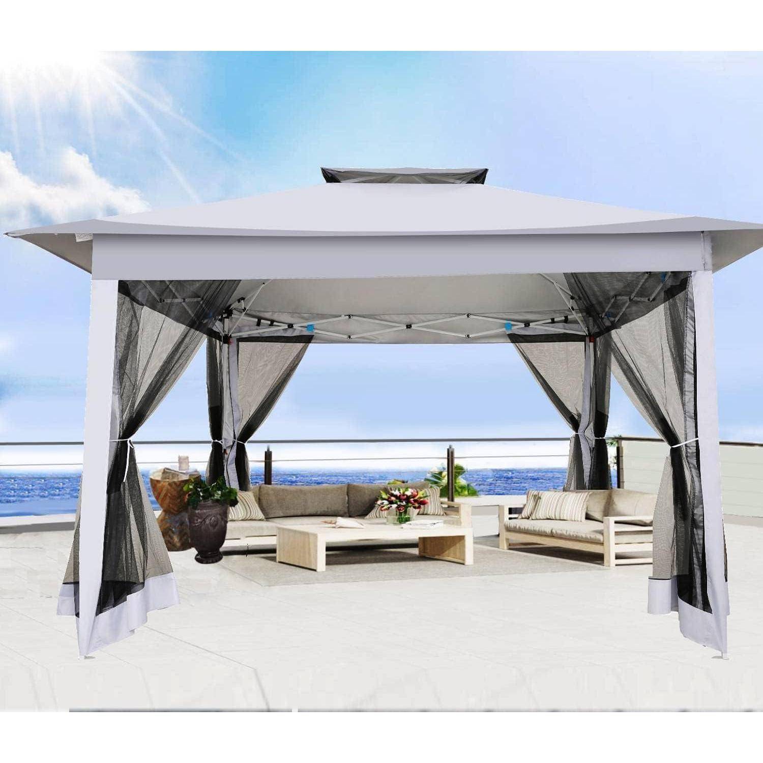 Weiße Außenkabine mit durchscheinenden Vorhängen, Sofas, Couchtisch und Blumen auf einer sonnigen Terrasse am Meer mit Blick auf den Ozean.