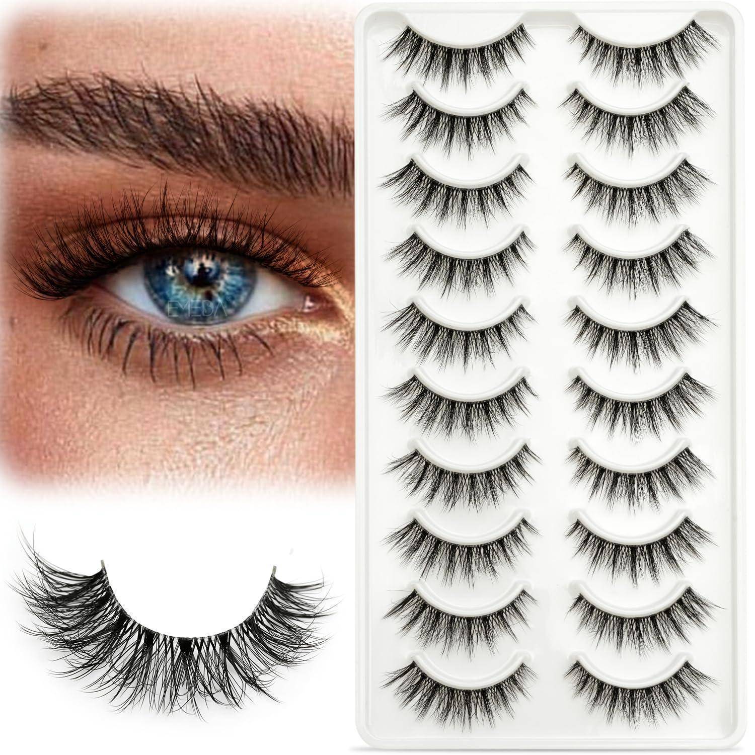 Nahaufnahme eines blauen Auges mit dramatischen falschen Wimpern, daneben ein Tablett mit mehreren Paar schwarzen Wimpernverlängerungen.