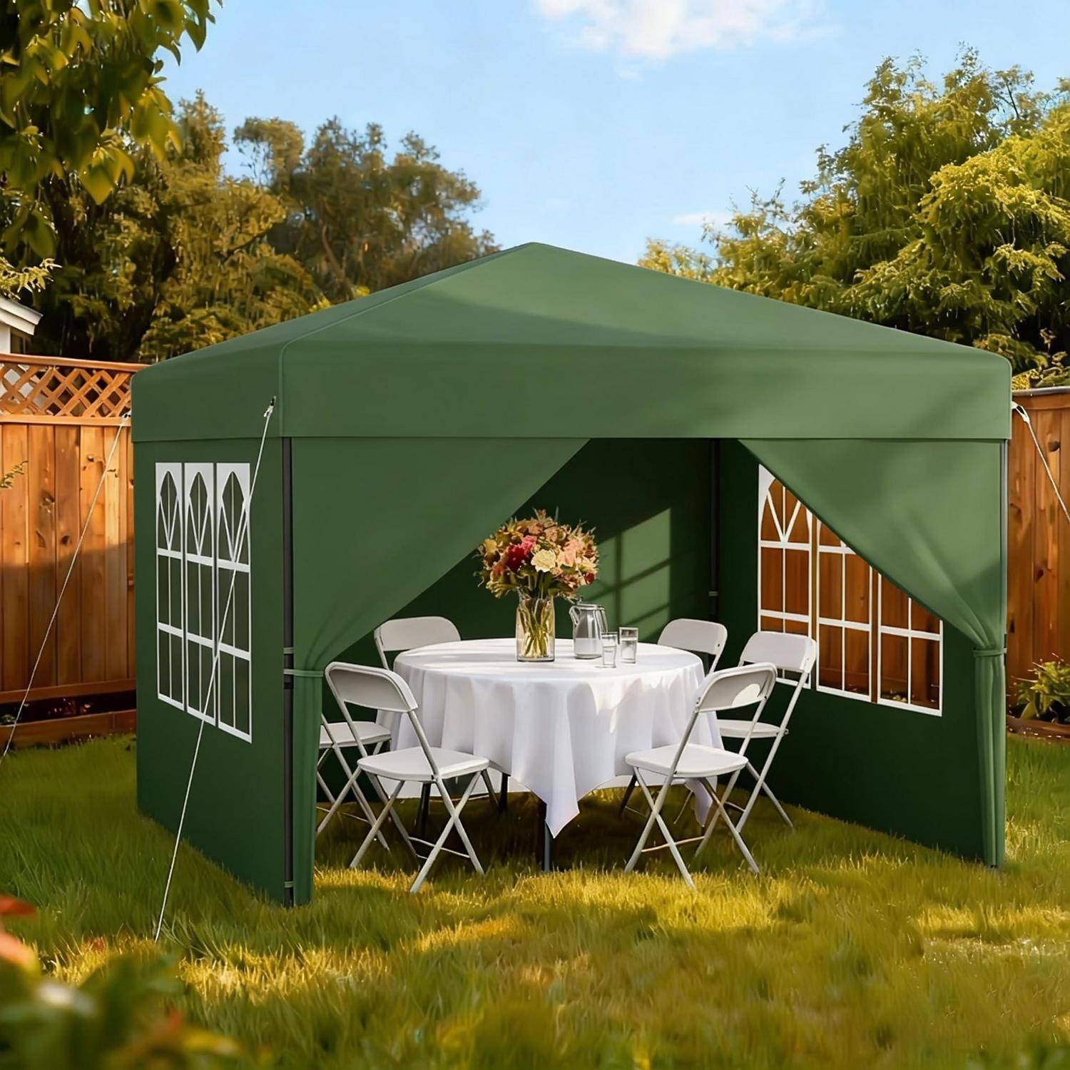 Grünes Outdoor-Zelt mit Baldachin im Hinterhof, aufgebaut mit einem runden Tisch, weißen Klappstühlen und einer Blumenmittelstückverzierung für ein kleines Treffen.