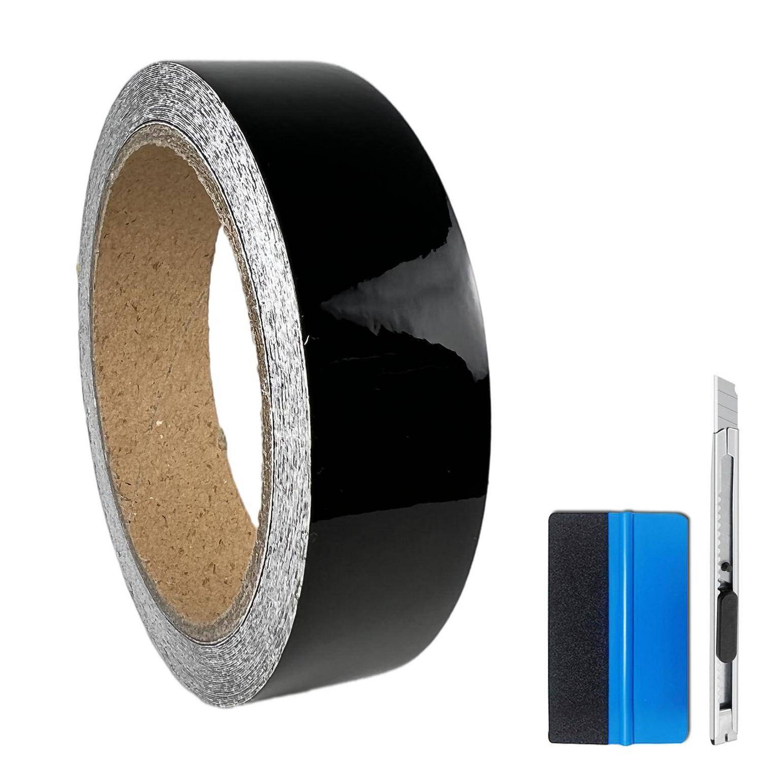 Rolle schwarzes Klebeband mit ablösbarem Spachtel und Universalmesser auf weißem Hintergrund.