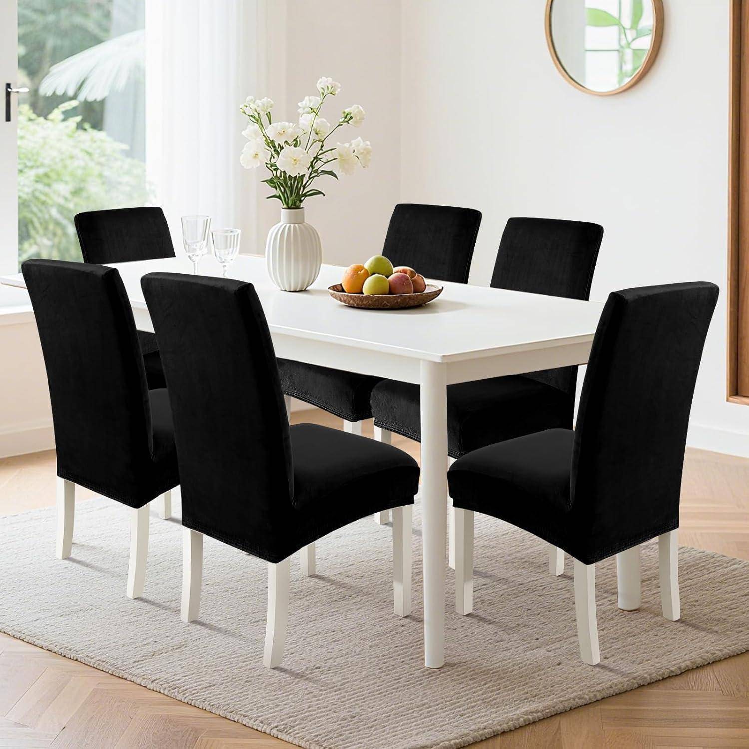 Modernes Esszimmer mit weißem Tisch, sechs schwarzen Stühlen, einer Vase mit weißen Blumen und einer Obstschale auf einem hellen Teppich neben einem Fenster.
