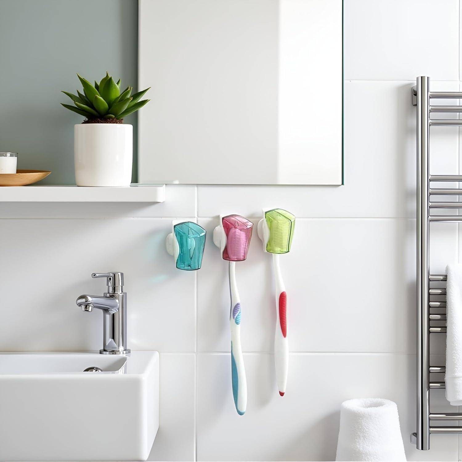 Modernes Badezimmer mit einem Waschbecken, an der Wand befestigten Zahnbürstenhaltern, weißen Handtüchern, einem Handtuchtrockner und einer Topfpflanze auf einem Regal.
