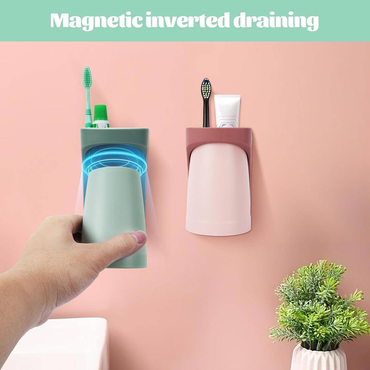 Hand hält einen magnetisch wandmontierten Badezimmerorganizer mit Zahnbürste und Zahnpasta; ein weiterer passender Organizer und eine Topfpflanze befinden sich an einer rosa Wand, mit dem Text „Magnetisch umgekehrtes Abtropfen