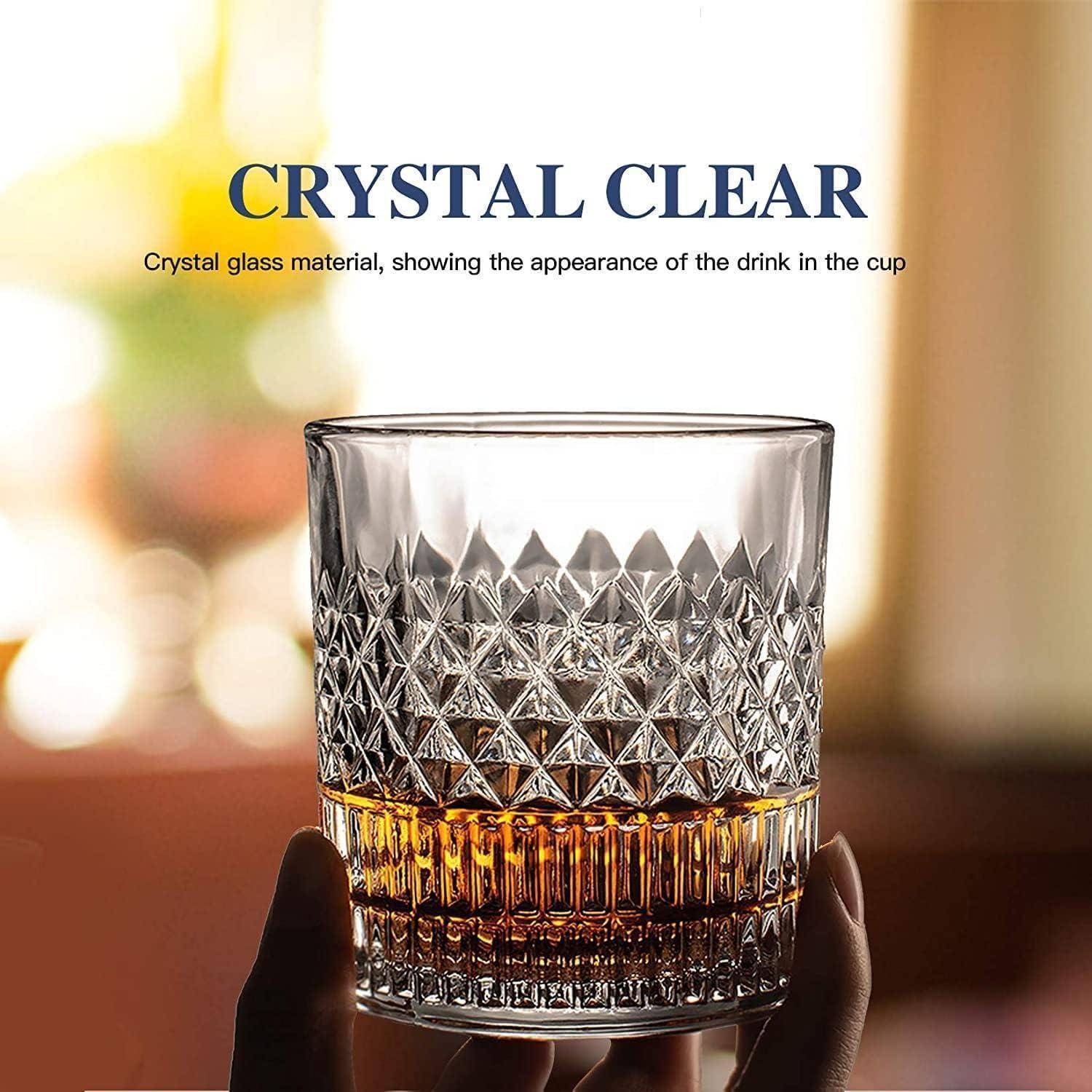 Kristallklarer facettierter Glasbecher in der Hand gehalten, das Getränk durch das durchsichtige strukturierte Design zeigend.