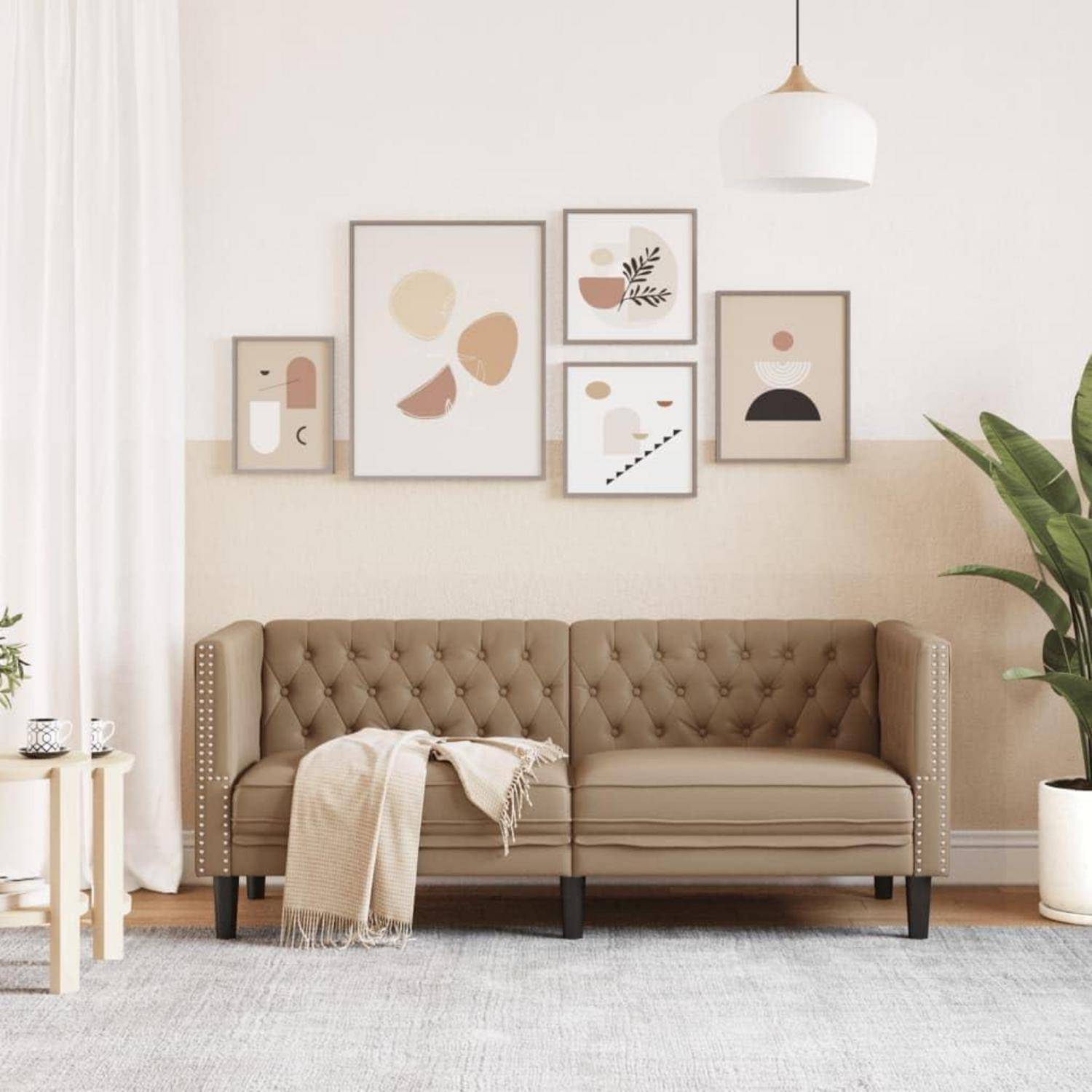 Modernes Wohnzimmer mit einem beige gesteppten Sofa, abstrakten gerahmten Wandgemälden, Pendelleuchte, Topfpflanze und einer beige Decke über dem Sofa drapiert.