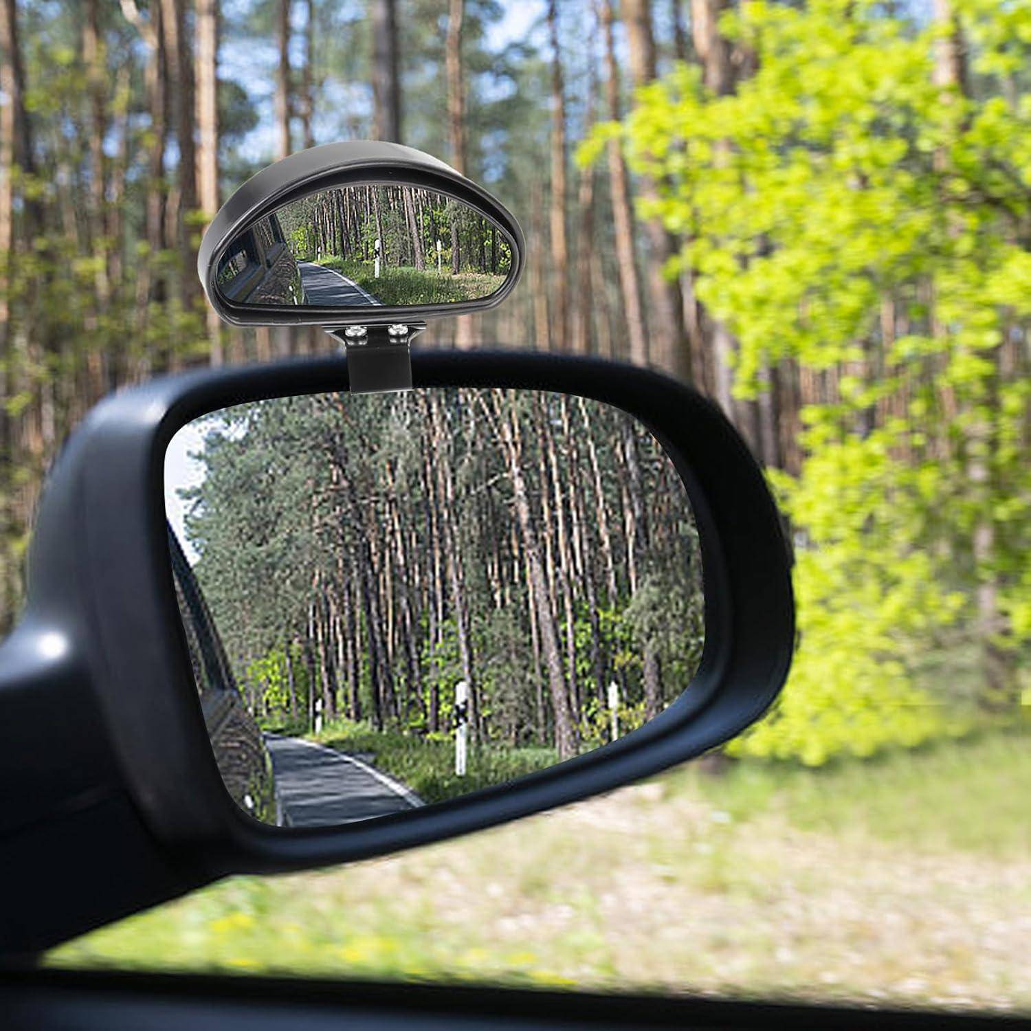 Beifahrerspiegel und kleiner Rückspiegel, die eine von Bäumen gesäumte Straße durch einen Wald reflektieren.