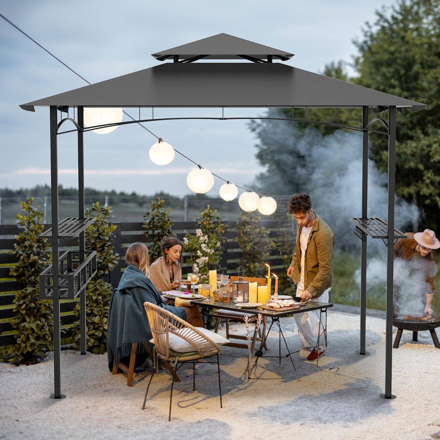 Freunde versammeln sich zu einem Außenessen unter einem Pavillon in der Dämmerung, mit einem beleuchteten Tisch, hängenden Laternen und einem Grill in der Nähe.