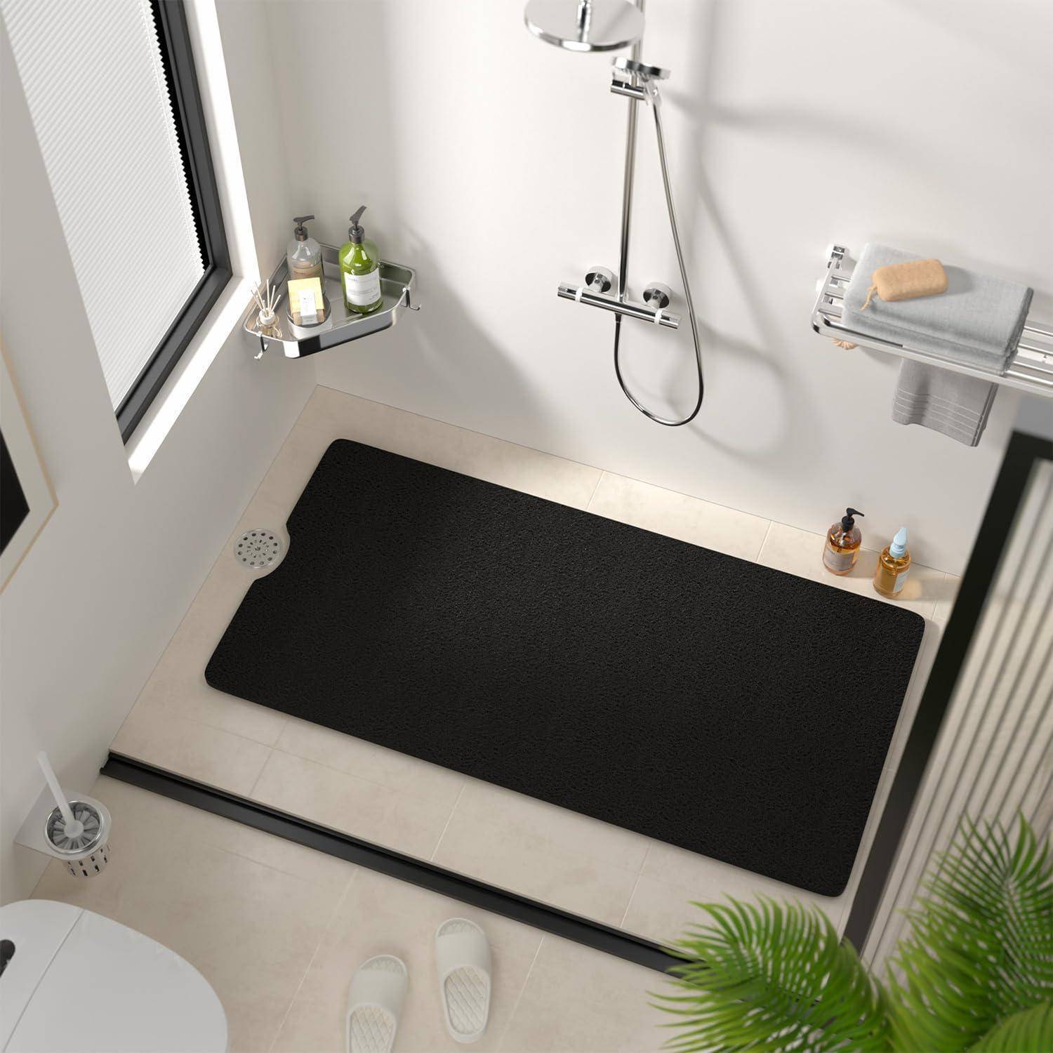 Modernes Badezimmer mit schwarzer Badmatte, wandmontierter Dusche, Eckregal mit Flaschen, Handtuchhalter und einer Topfpflanze im Vordergrund.