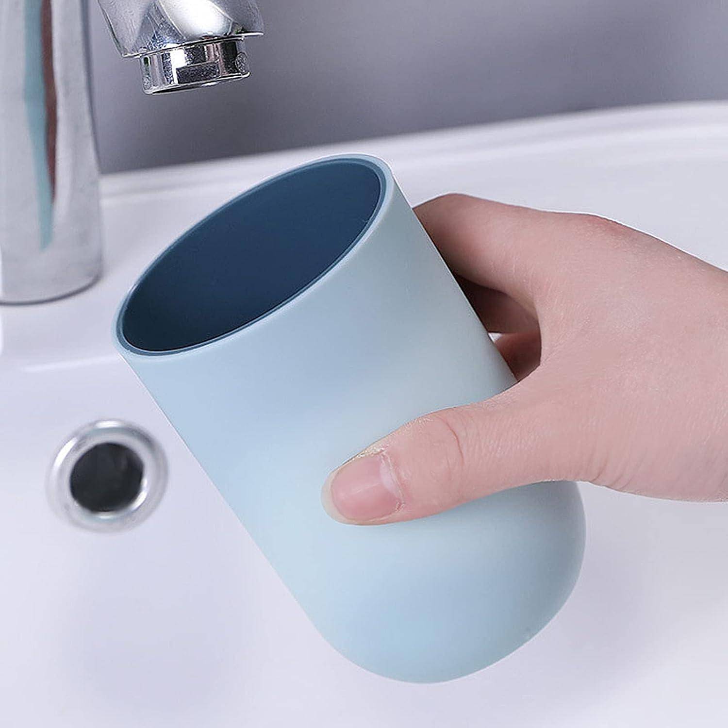 Eine Hand, die eine hellblaue Tasse unter einem Badezimmerhahn über einem Waschbecken hält, so als würde sie diese mit Wasser füllen.