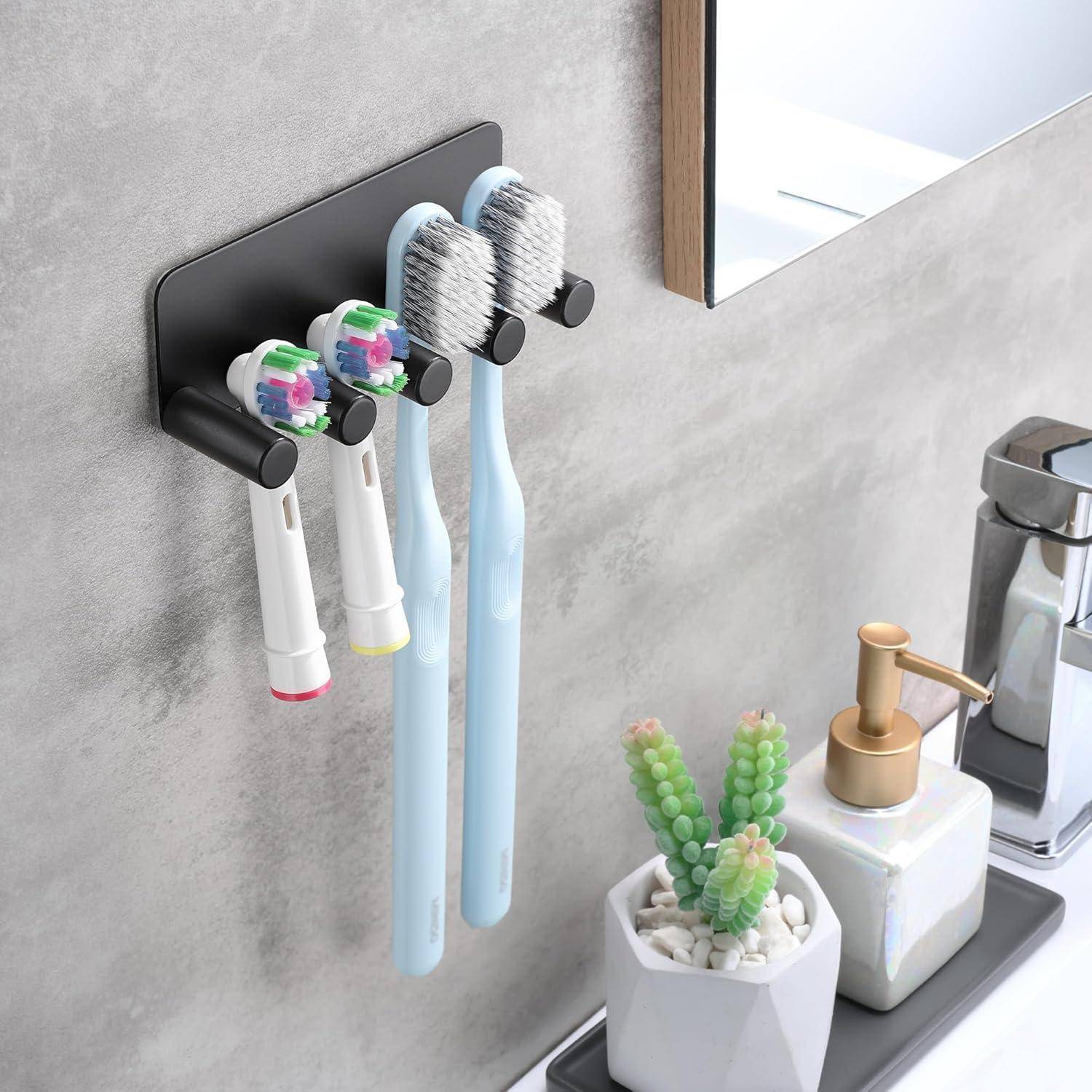 An der Wand befestigter Zahnbürstenhalter mit vier Zahnbürsten über einer Badezimmerablage, neben einem Waschbecken, einem Seifenspender und einer kleinen Sukkulente.