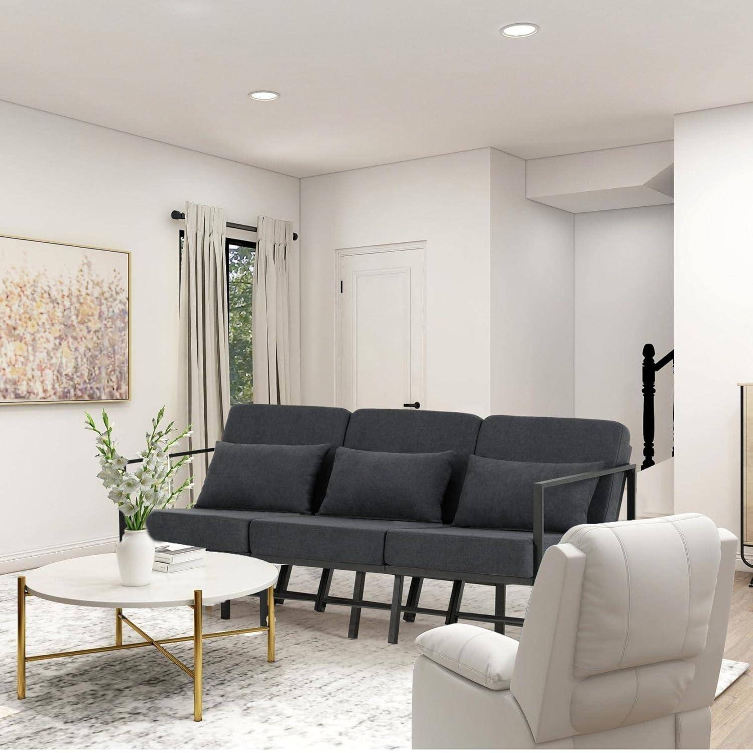 Modernes Wohnzimmer mit dunkelgrauem Sofa, weißem Sessel, rundem Couchtisch, Wandkunst und weicher, neutraler Dekoration.
