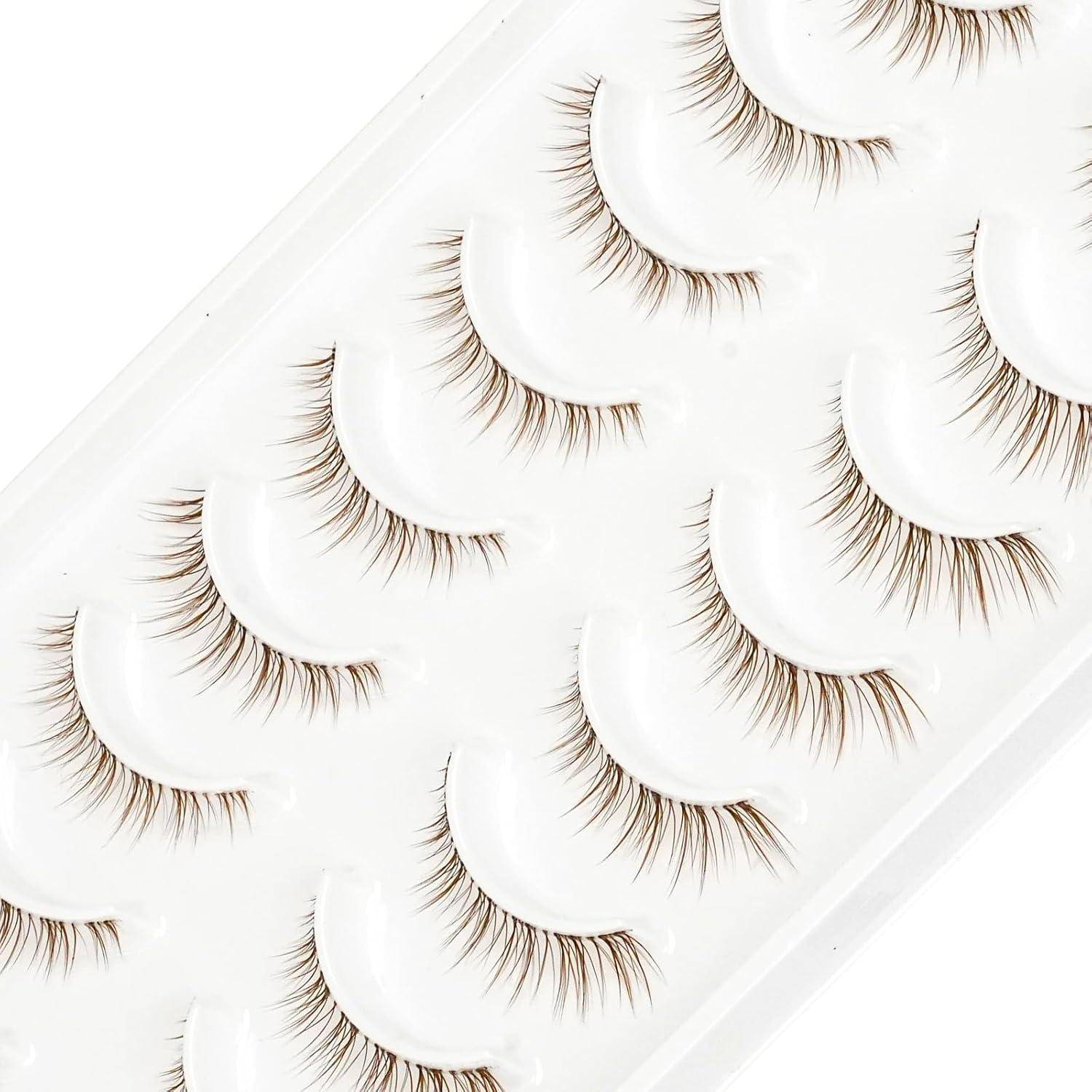 Tablett mit künstlichen Wimpern in Reihen auf weißem Hintergrund