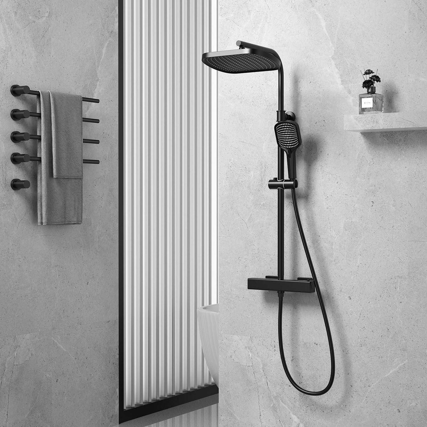 Modernes Badezimmer mit einer schwarzen Regendusche und einer Handbrause neben einer Glastrennwand, Handtuchhalter auf der linken Seite und einem kleinen Regal mit Pflanze auf der rechten Seite.