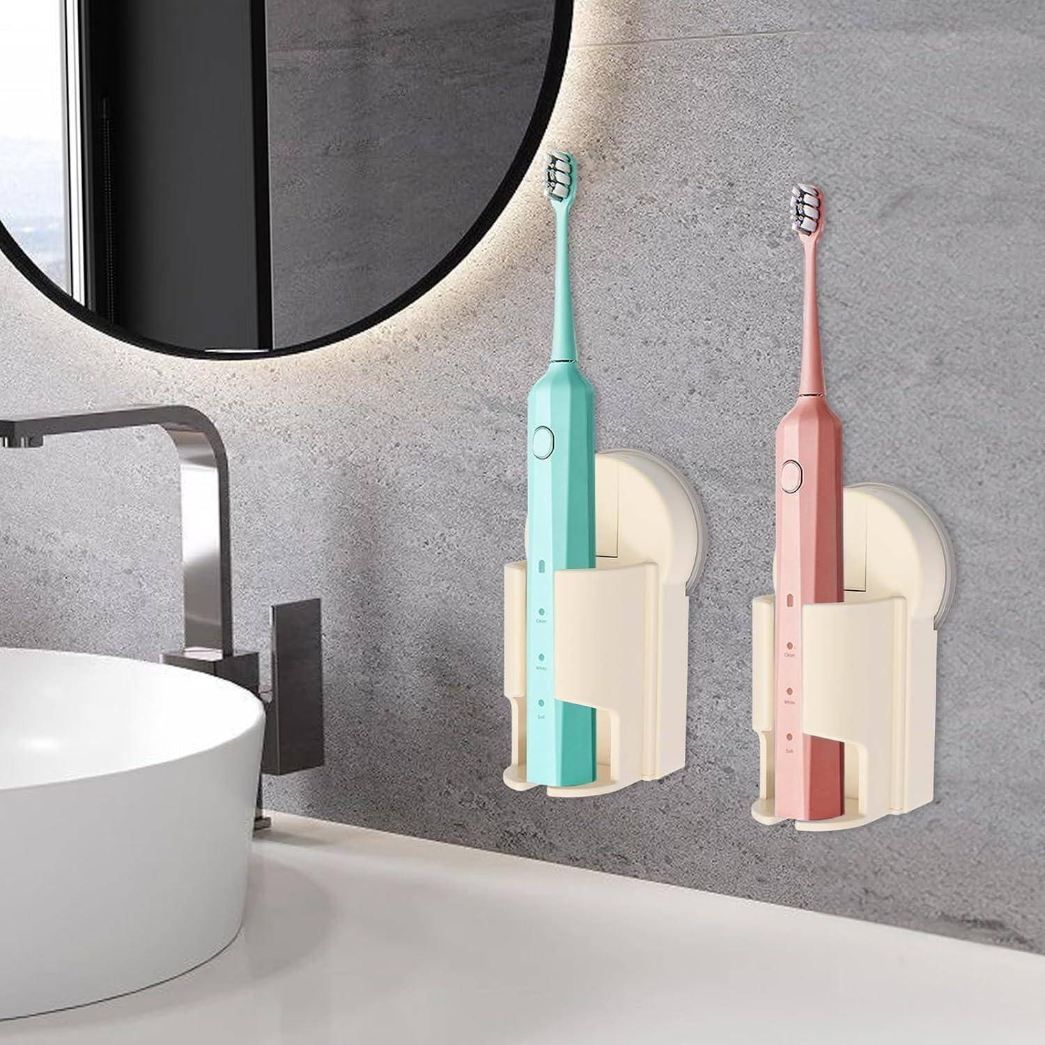 Zwei elektrische Zahnbürsten in wandmontierten Ladegeräten neben einem Badezimmerbecken und einem Spiegel.