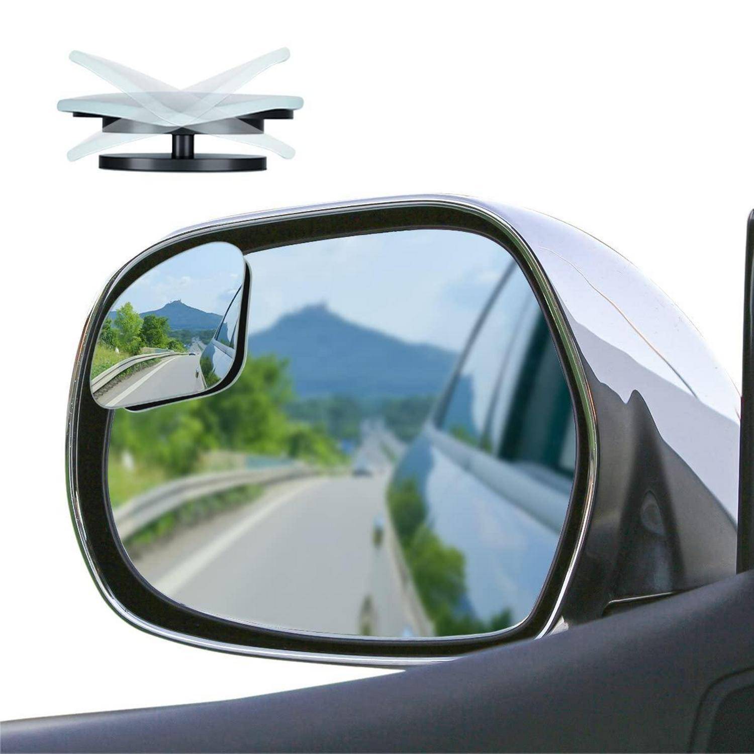 Außenspiegel eines Autos zeigt eine Straße und Berge dahinter, mit einem kleinen Totwinkel-Spiegel in der Ecke angebracht.
