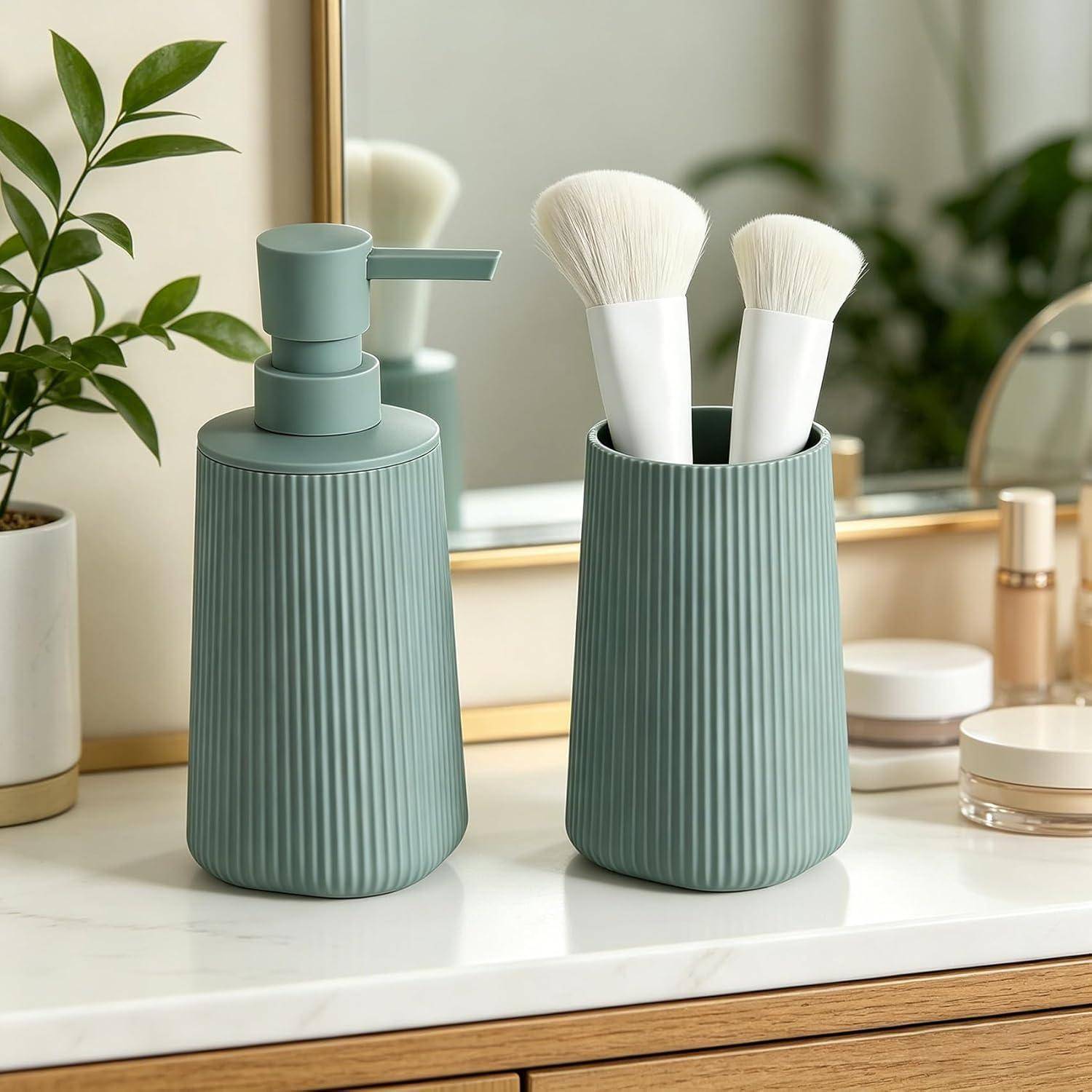 Zwei gerillte grüne Badezimmerbehälter auf einer Waschtischplatte, einer mit einer Pumpenspender und einer mit Makeup-Pinseln, mit einem Spiegel und Toilettenartikeln dahinter.