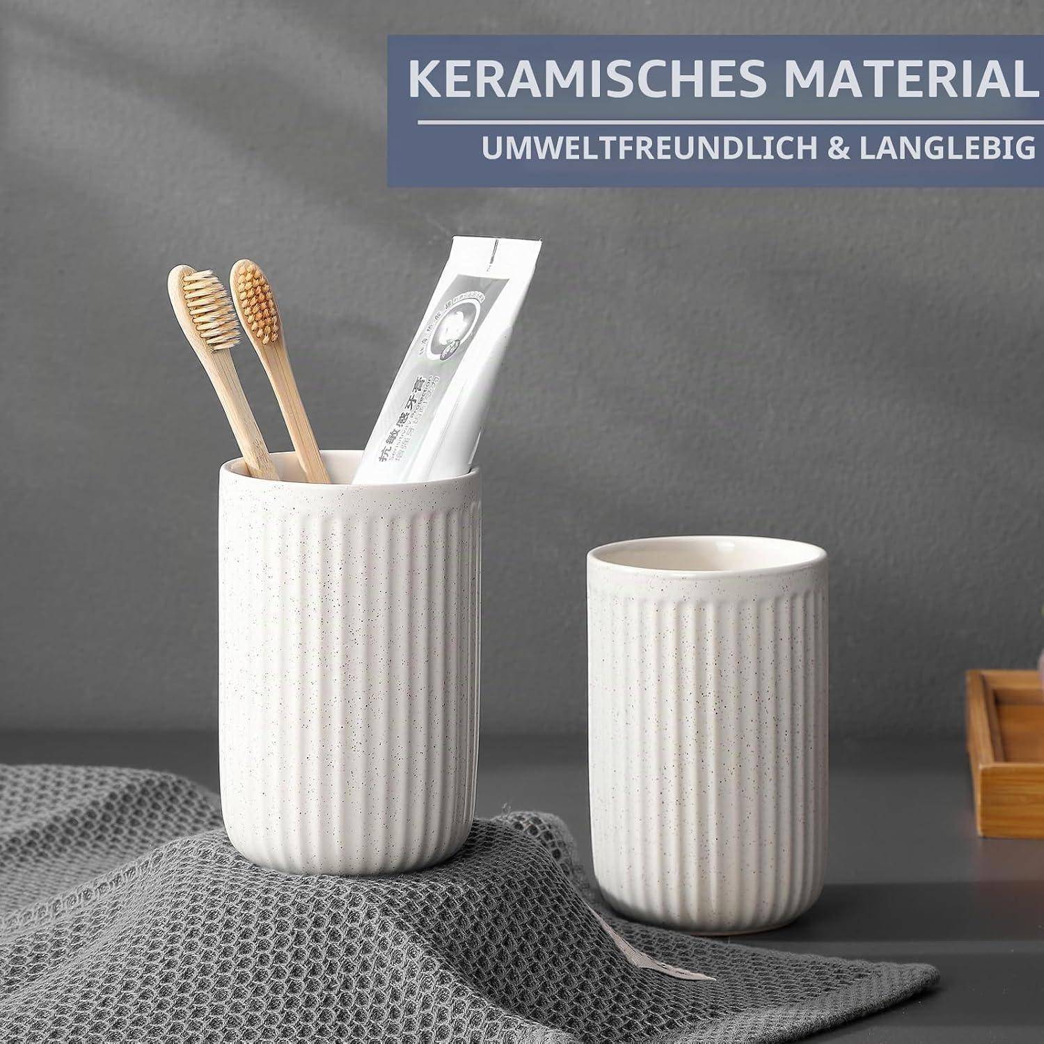 Zwei weiße gerippte Keramik-Zahnputzbecher, einer mit Bambuszahnbürsten und einer Zahnpastatube, mit deutschem Text „KERAMISCHES MATERIAL