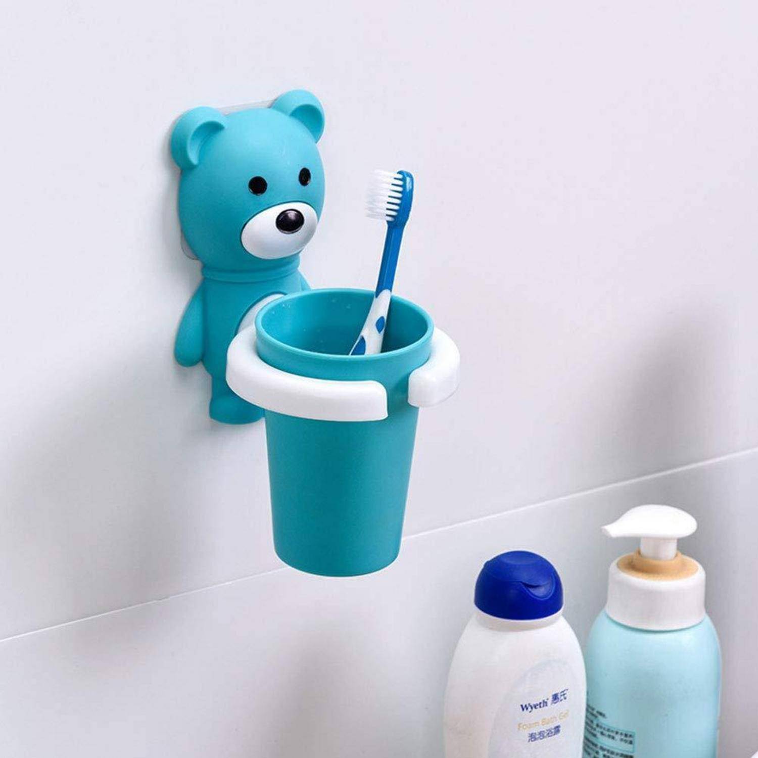 Blauer Bärwandhalter mit einer Zahnbürste und einem Becher über zwei Badezimmerfläschchen an einer gefliesten Wand.